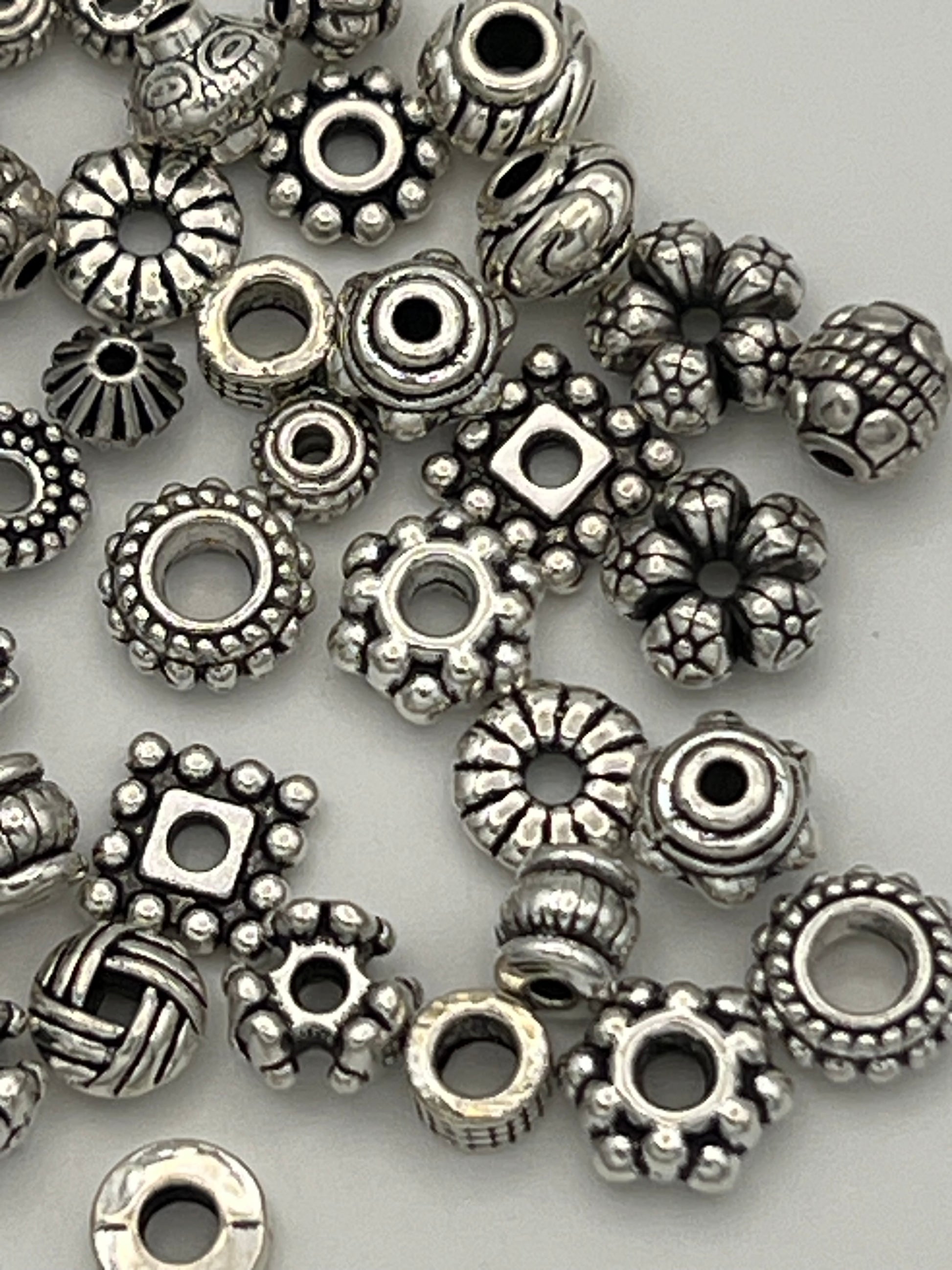 50 mixed Tibetan style spacer beads in various shapes and sizes.