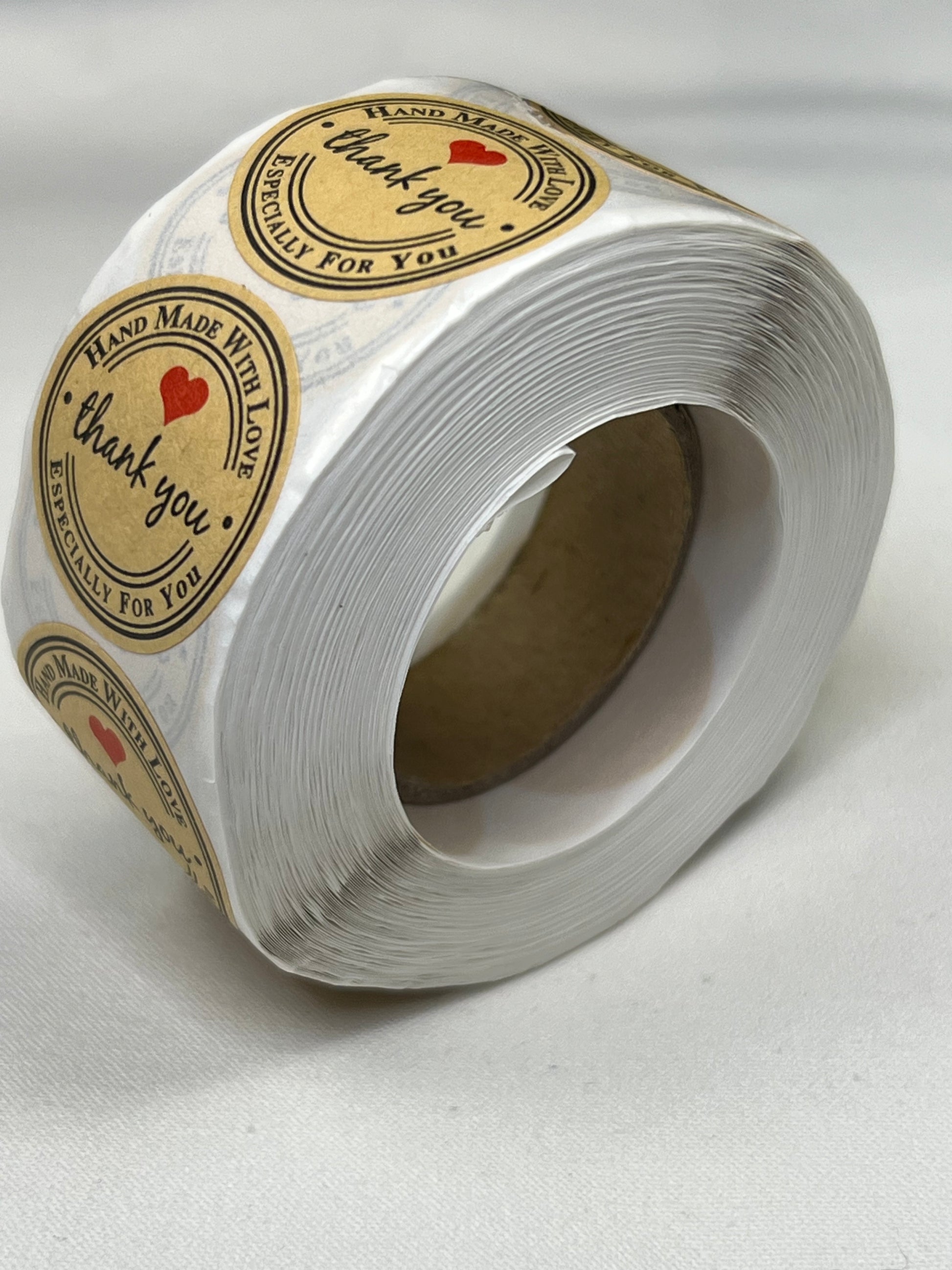 A roll of 1-inch kraft paper "Thank You" stickers with a red heart.