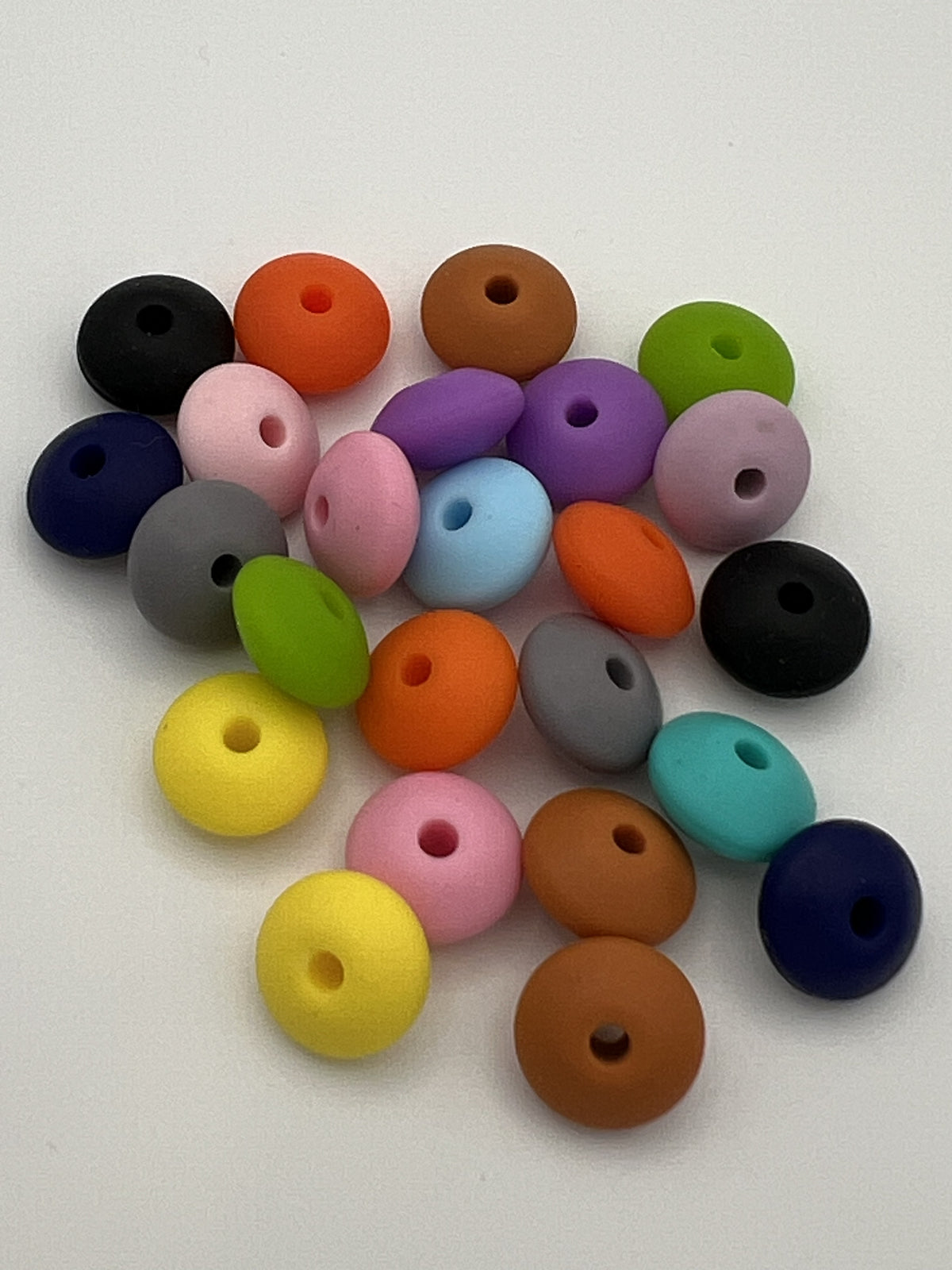 Assorted 12mm silicone abacus beads in a variety of matte colors on a white background.