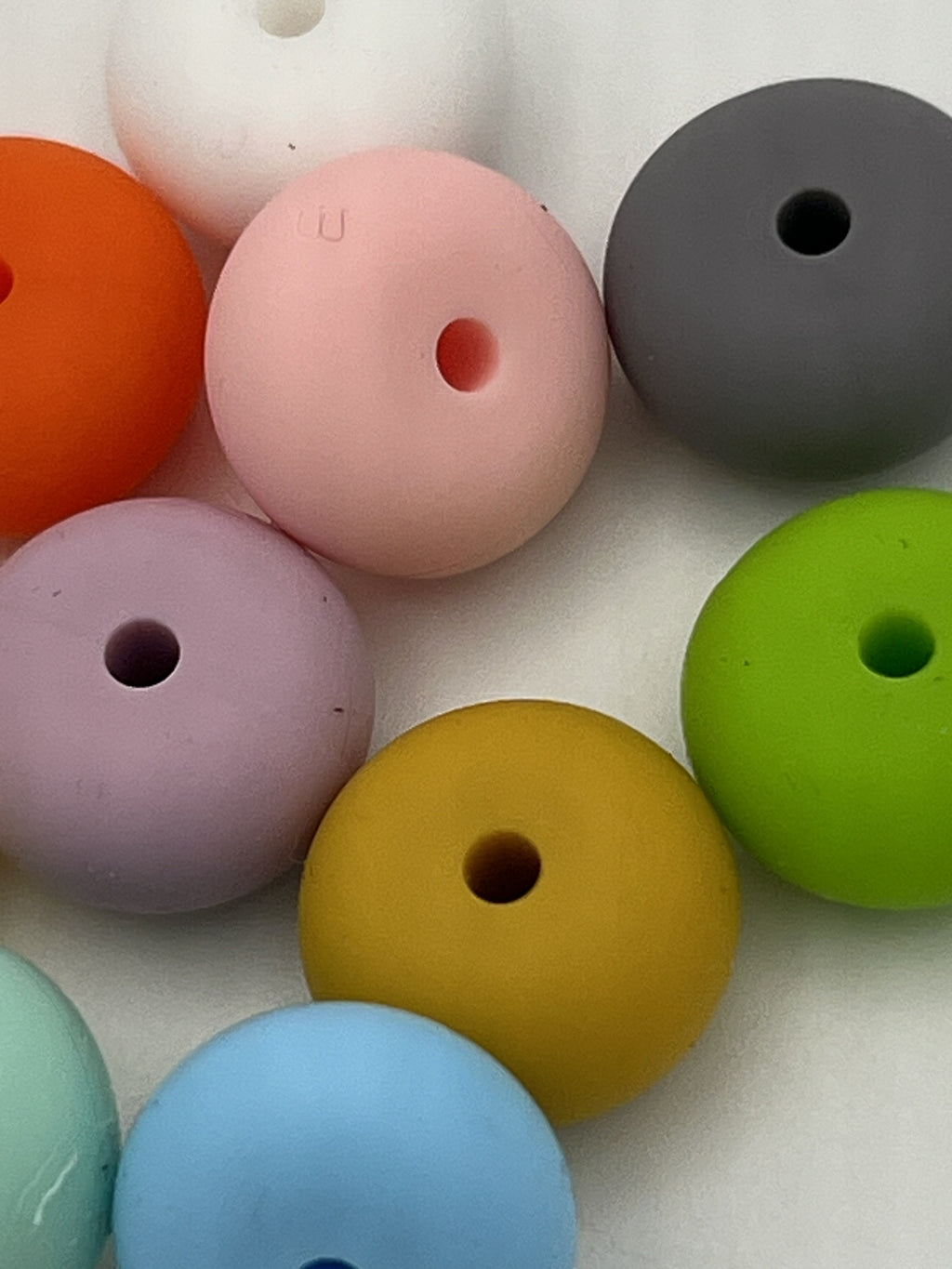 Assorted 14mm silicone abacus beads in various colors including pink, green, yellow, and blue.