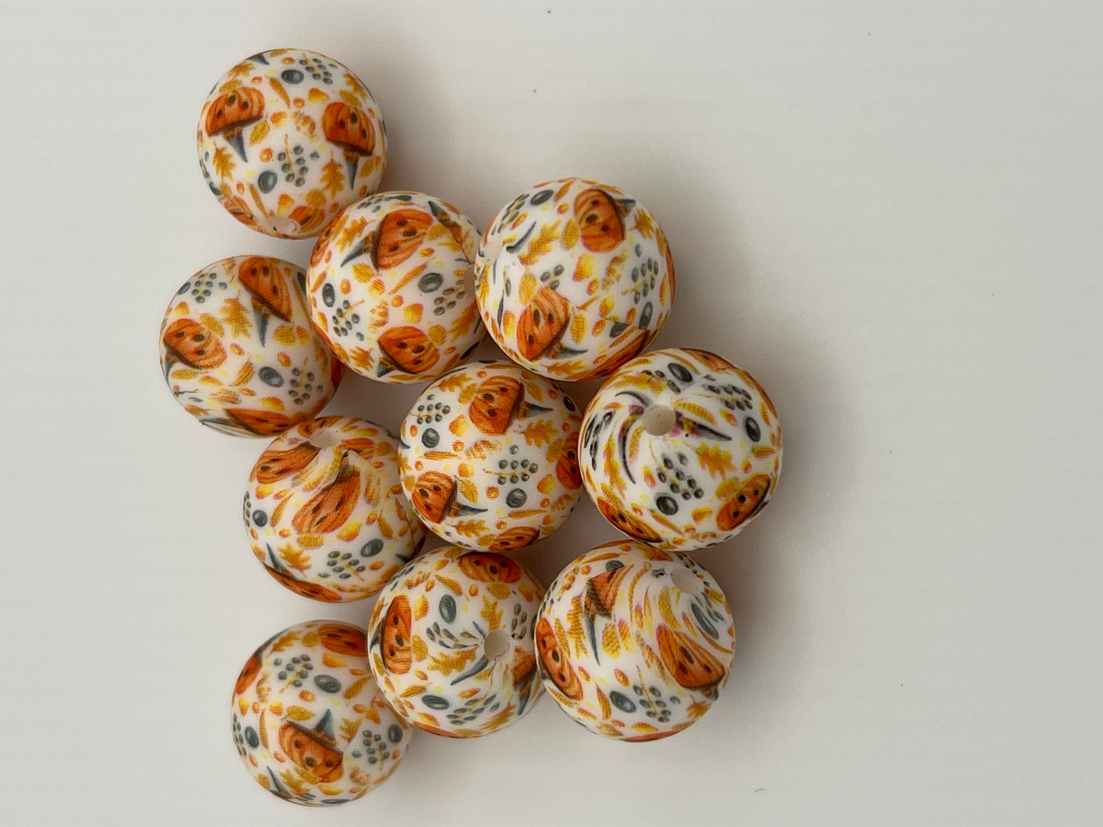 10 silicone beads with a Halloween pumpkin and leaf pattern.