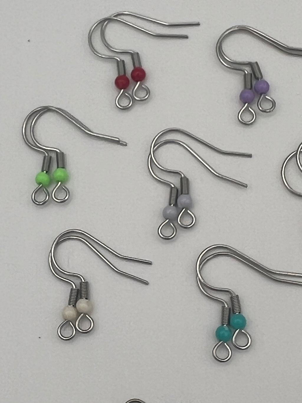 Stainless steel ear wires with acrylic beads in red, purple, green, gray, white, and teal.