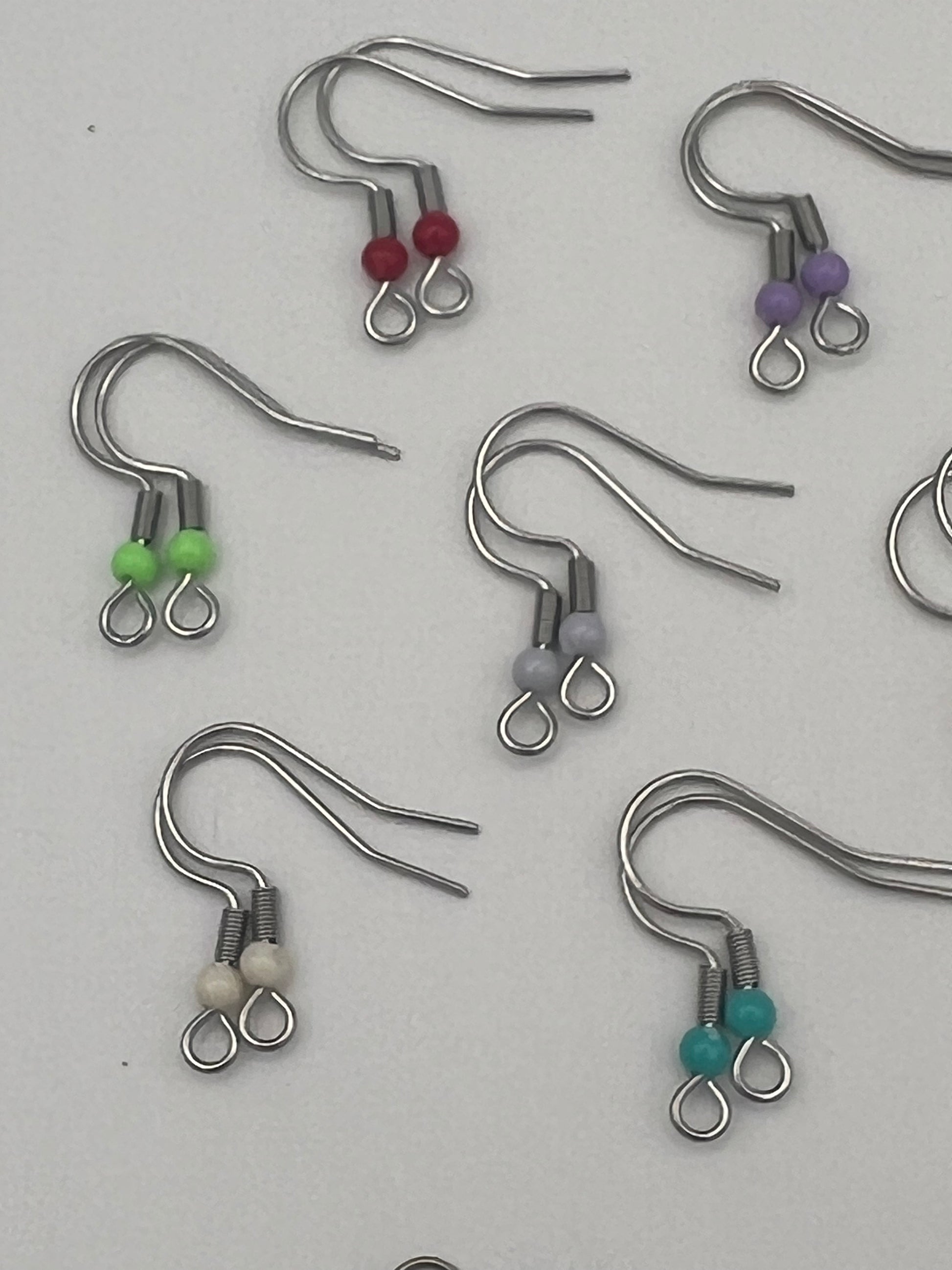 Stainless steel ear wires with acrylic beads in red, purple, green, gray, white, and teal.