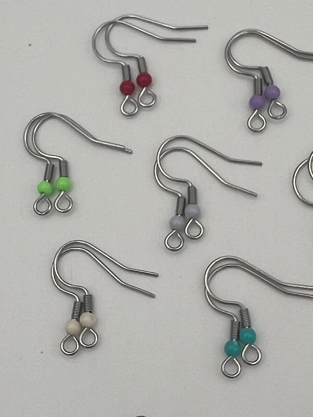 Stainless steel ear wires with acrylic beads in red, purple, green, gray, cream, and teal.