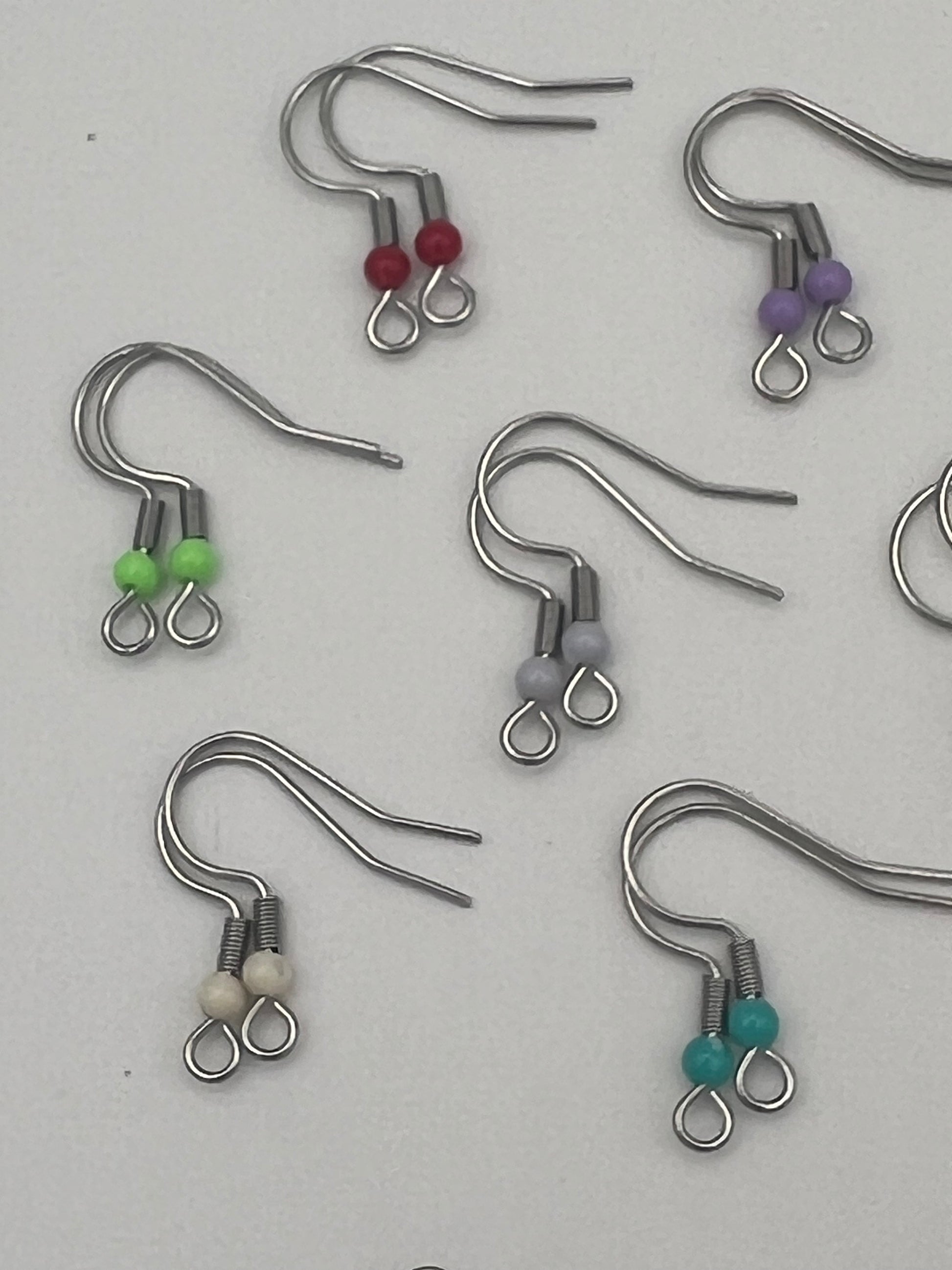 Stainless steel ear wires with acrylic beads in red, purple, green, gray, cream, and teal.