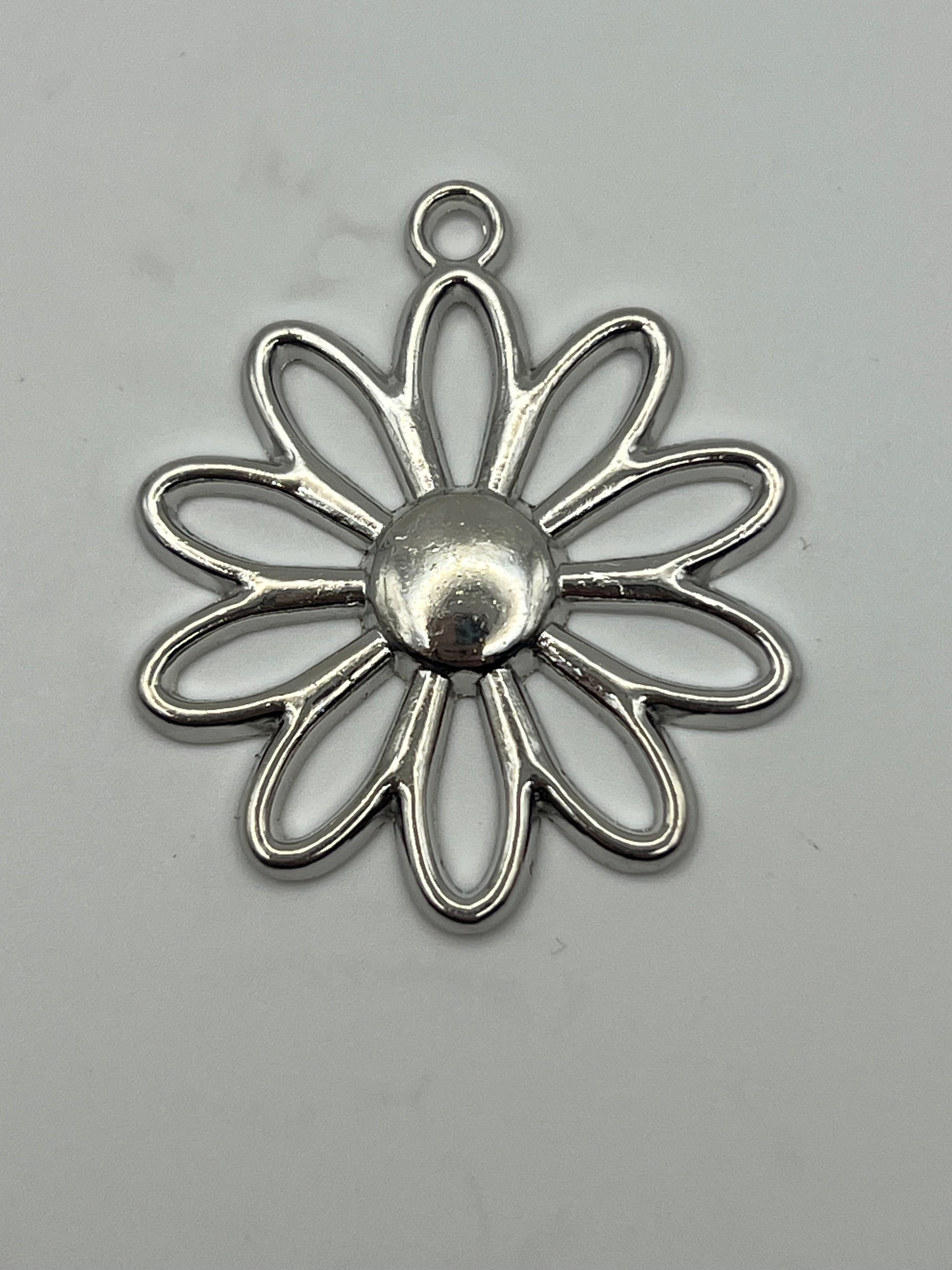 Silver-tone large daisy flower pendant with a central dome and loop.