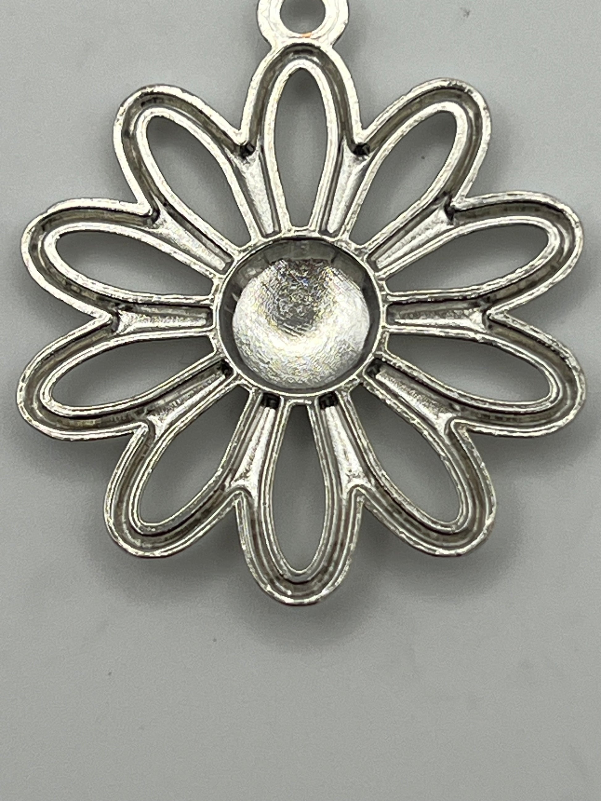 Large platinum daisy flower pendant with a textured center.
