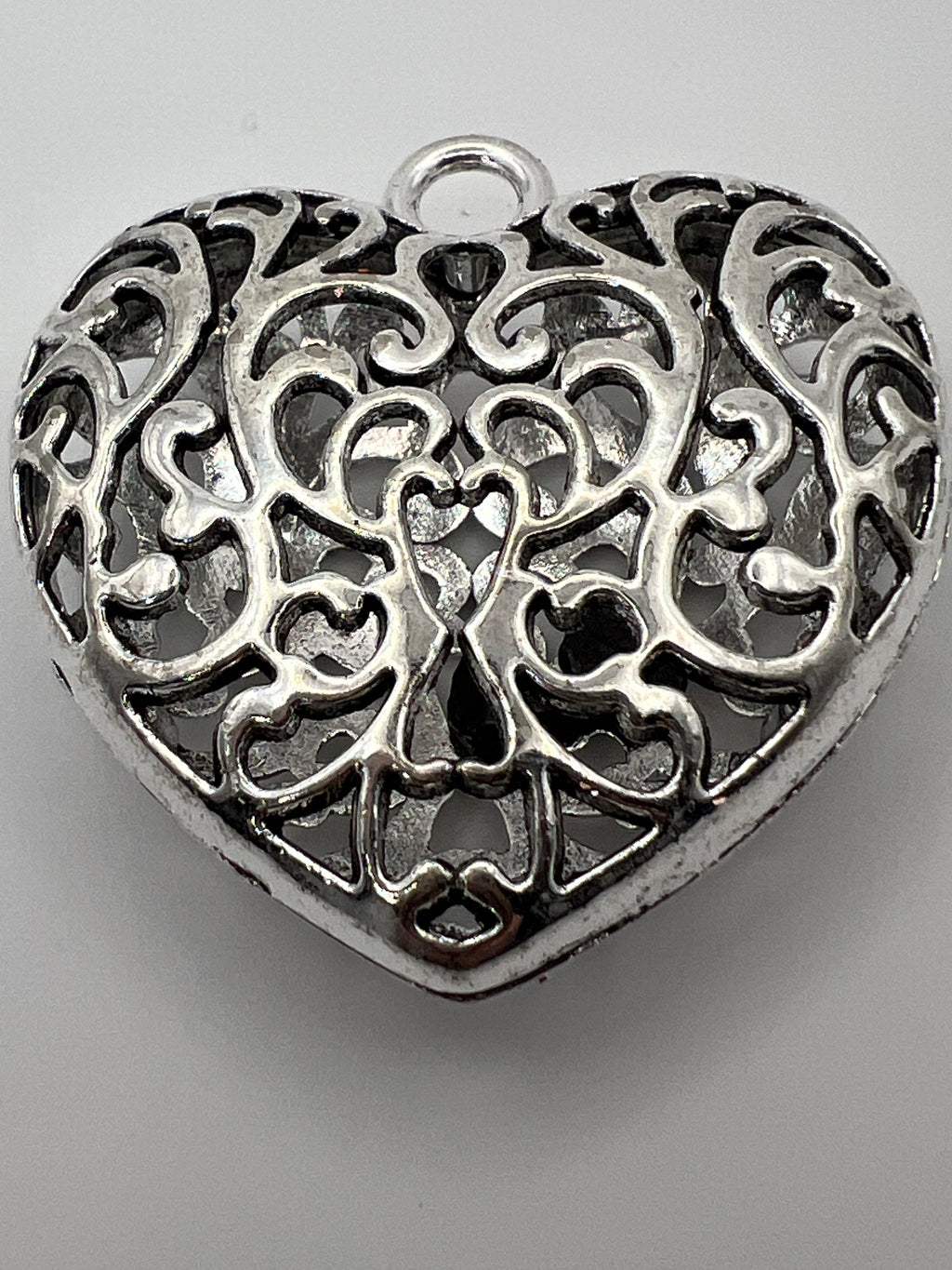 Silver Tibetan style hollow heart pendant with intricate detailing.