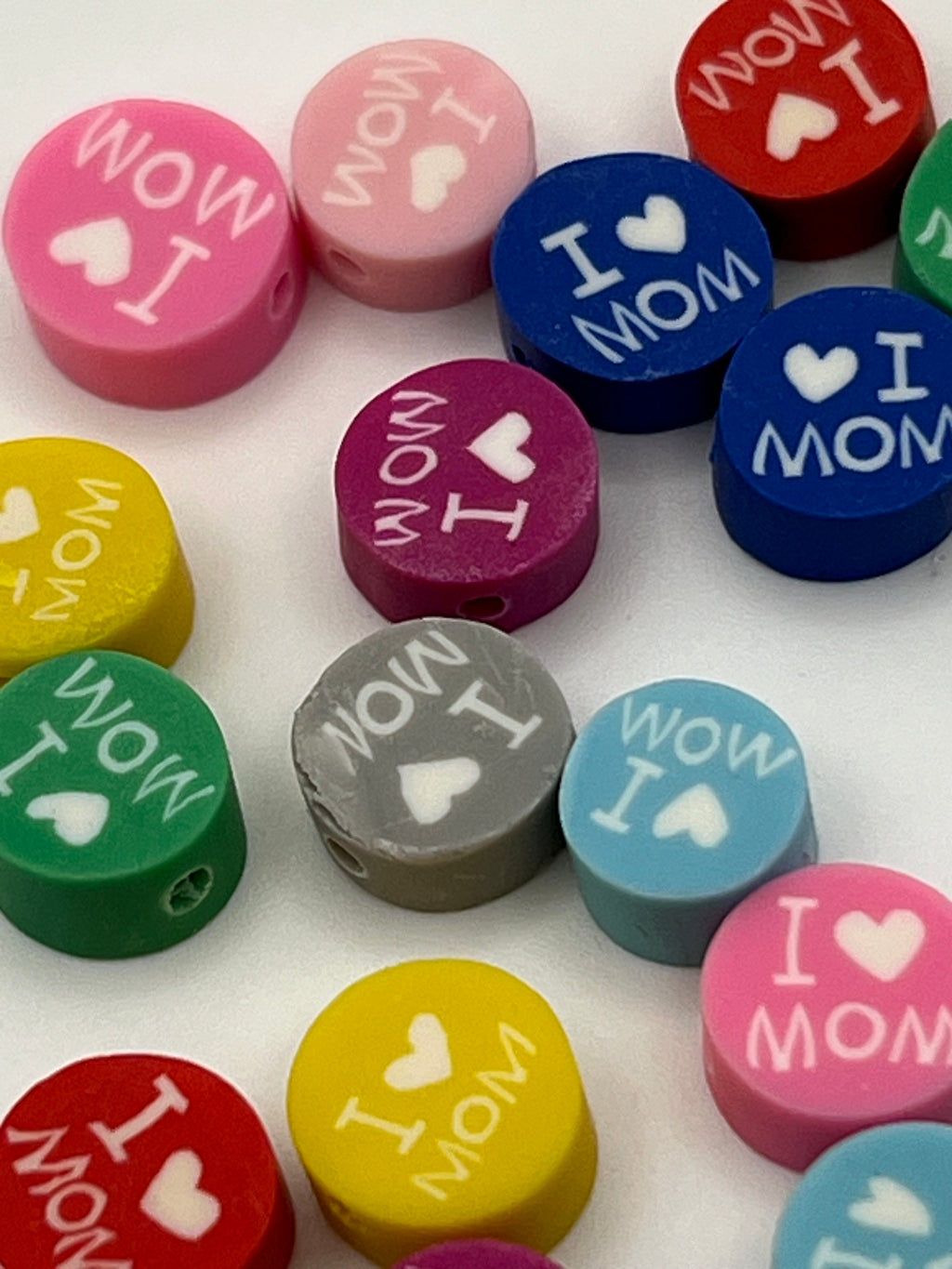 Colorful polymer clay beads with "I Love Mom" and heart designs.