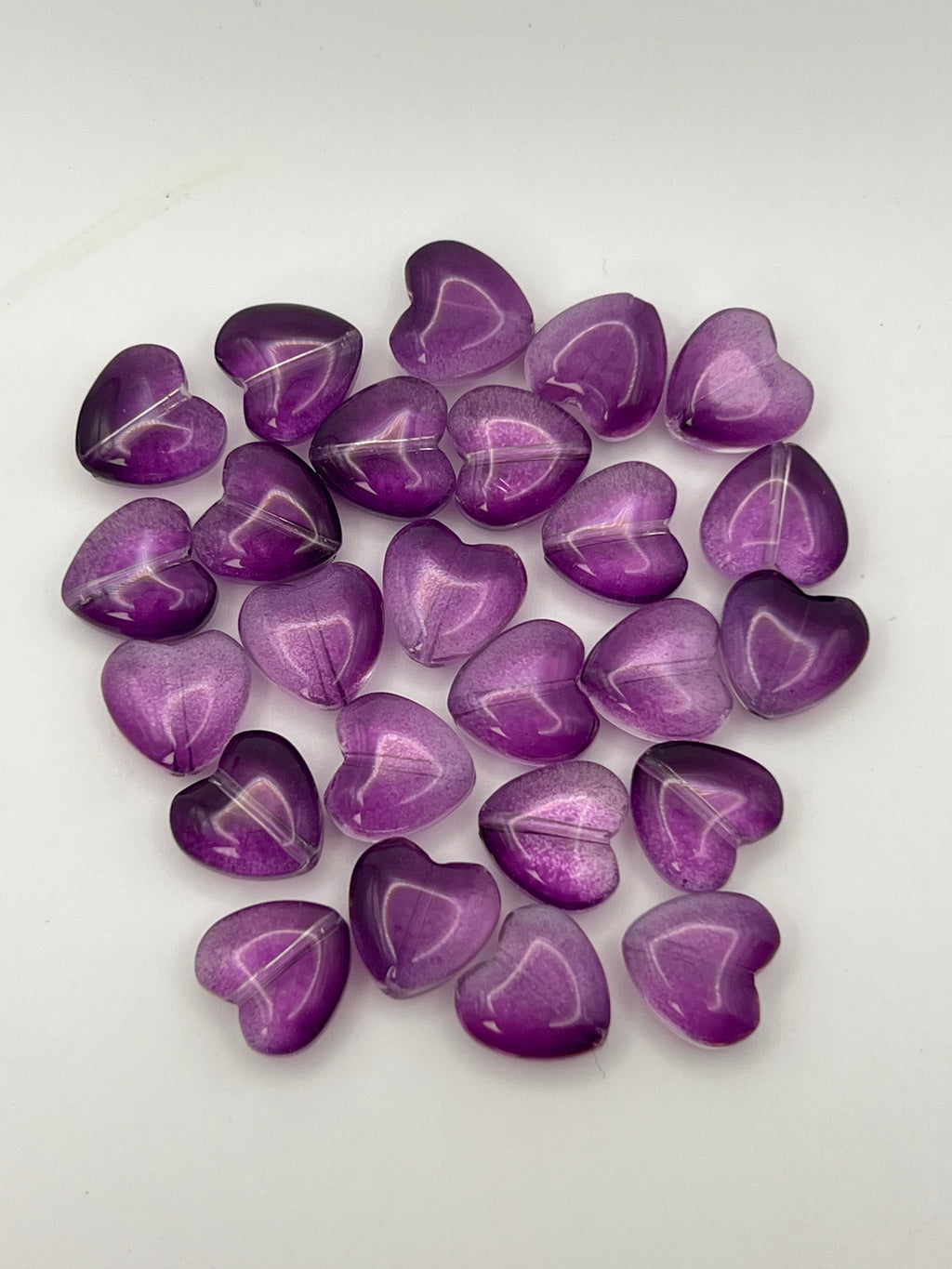 25 transparent purple glass heart beads.