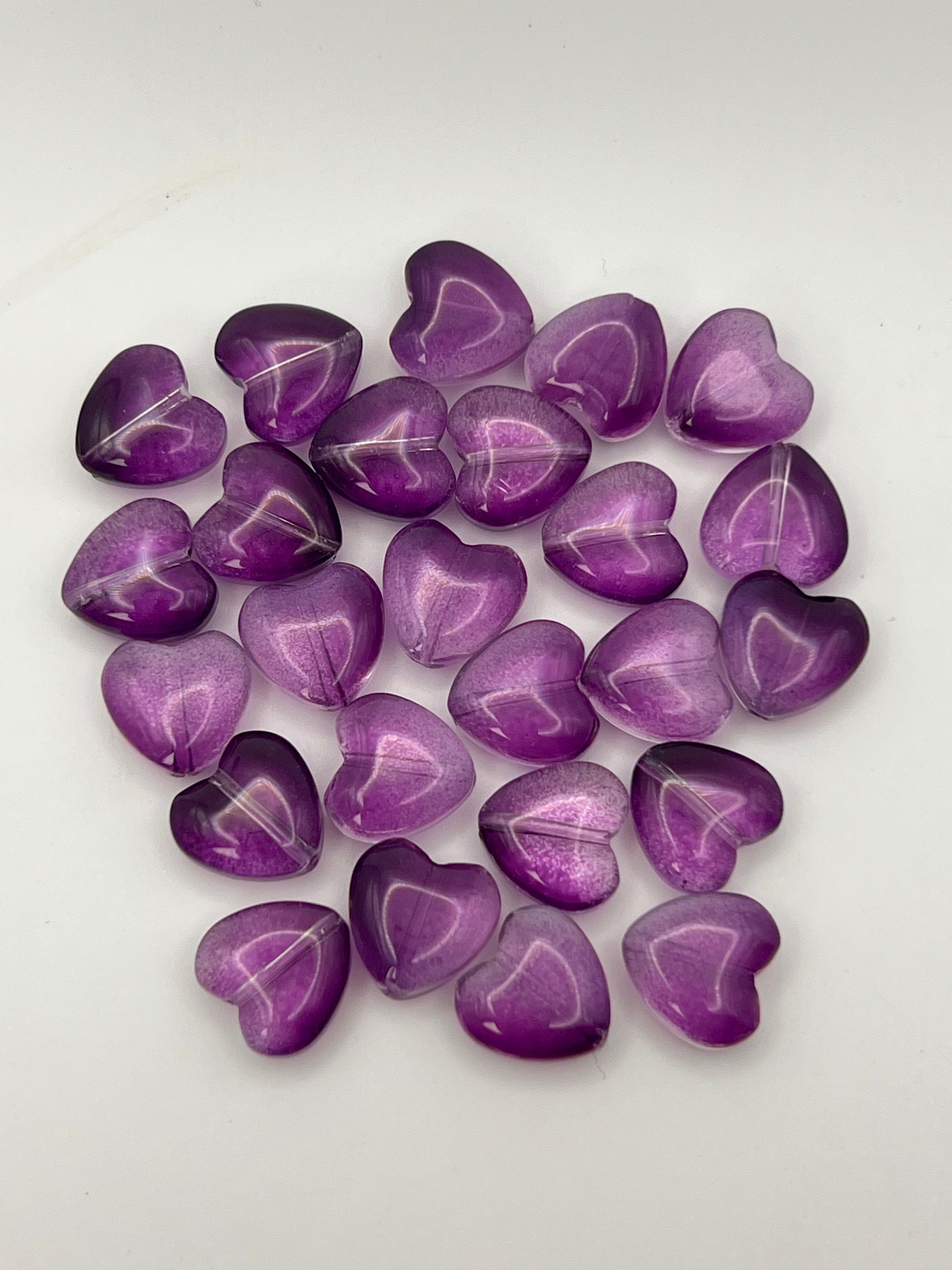 25 transparent purple glass heart beads.