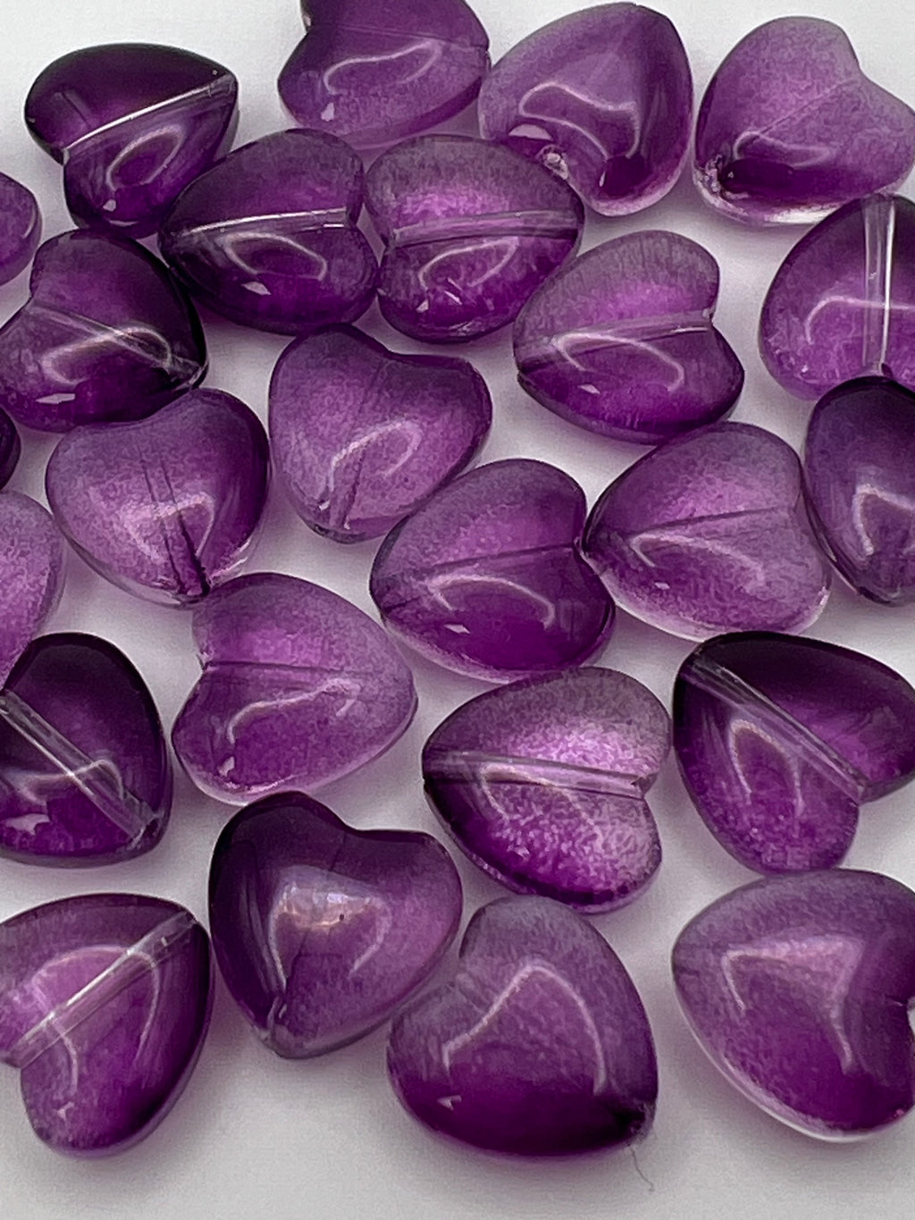 Transparent purple glass heart beads.