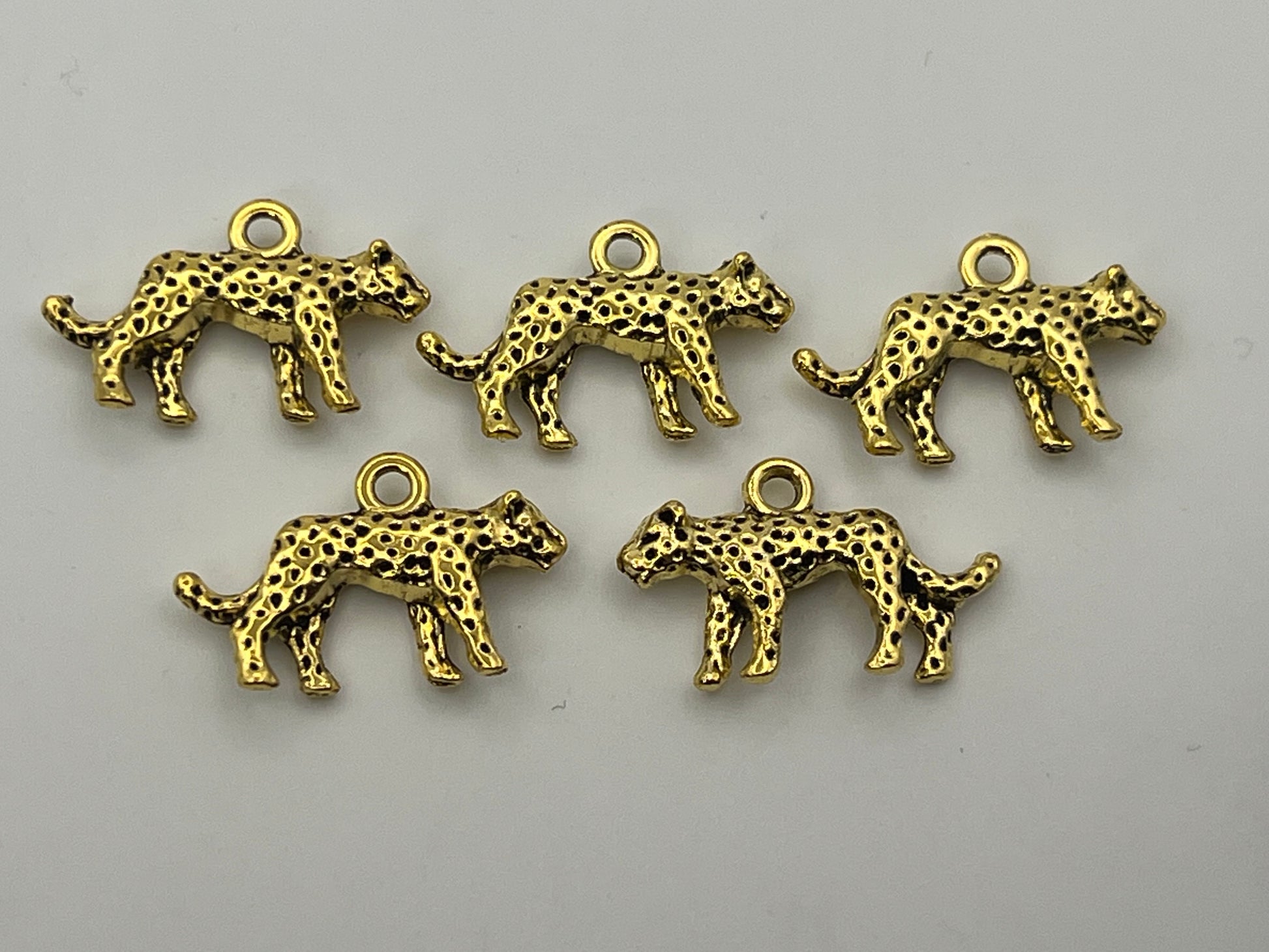 Five antique golden Tibetan style leopard charms.