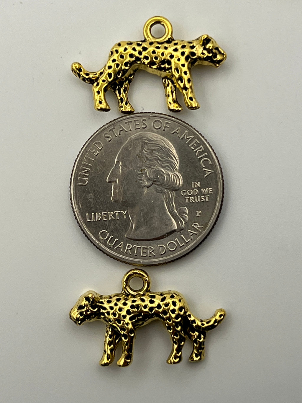 Five antique golden Tibetan style leopard charms with black spots.