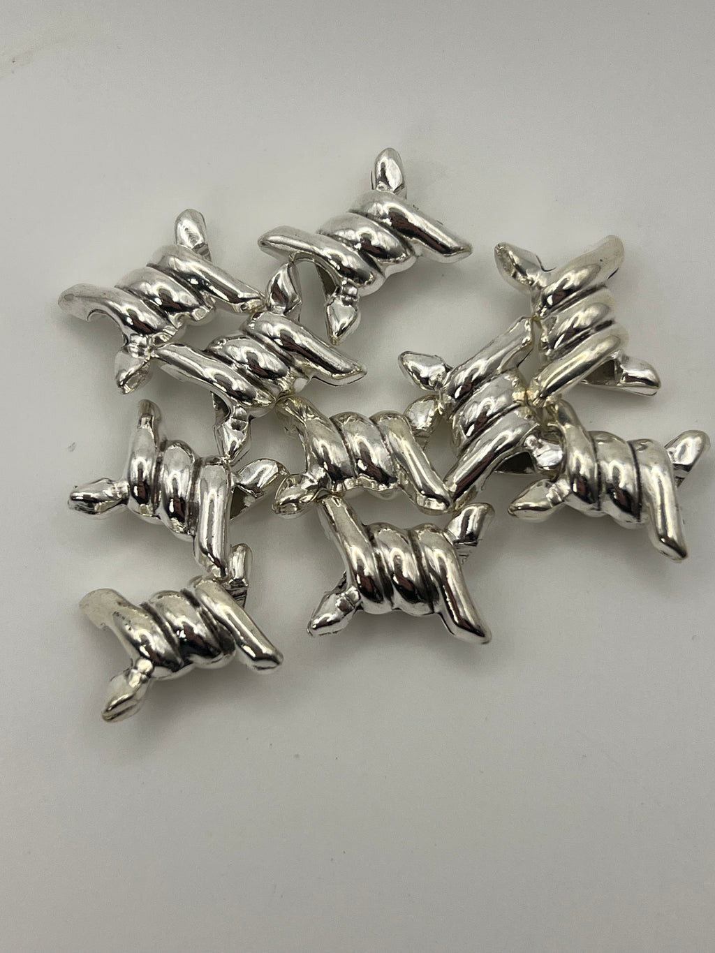 Silver-tone barbed wire European beads with a 4.5mm hole.