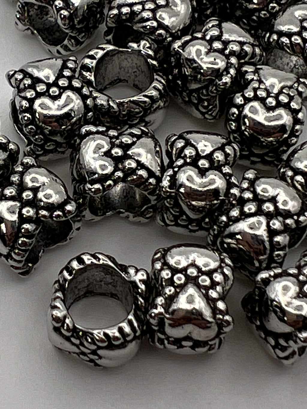 Tibetan style heart European beads with a braided edge.