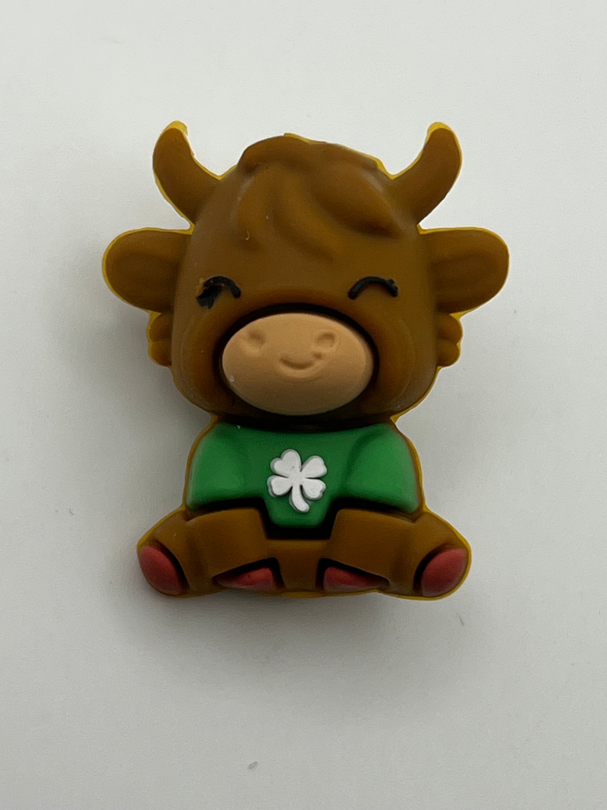 Silicone focal bead of a brown cow wearing a green shirt with a white clover.