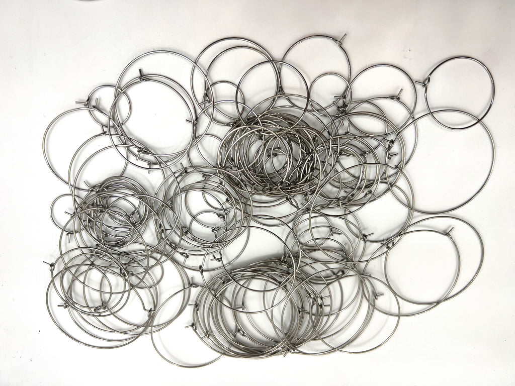 A pile of 120 stainless steel wine glass charm rings in various sizes.