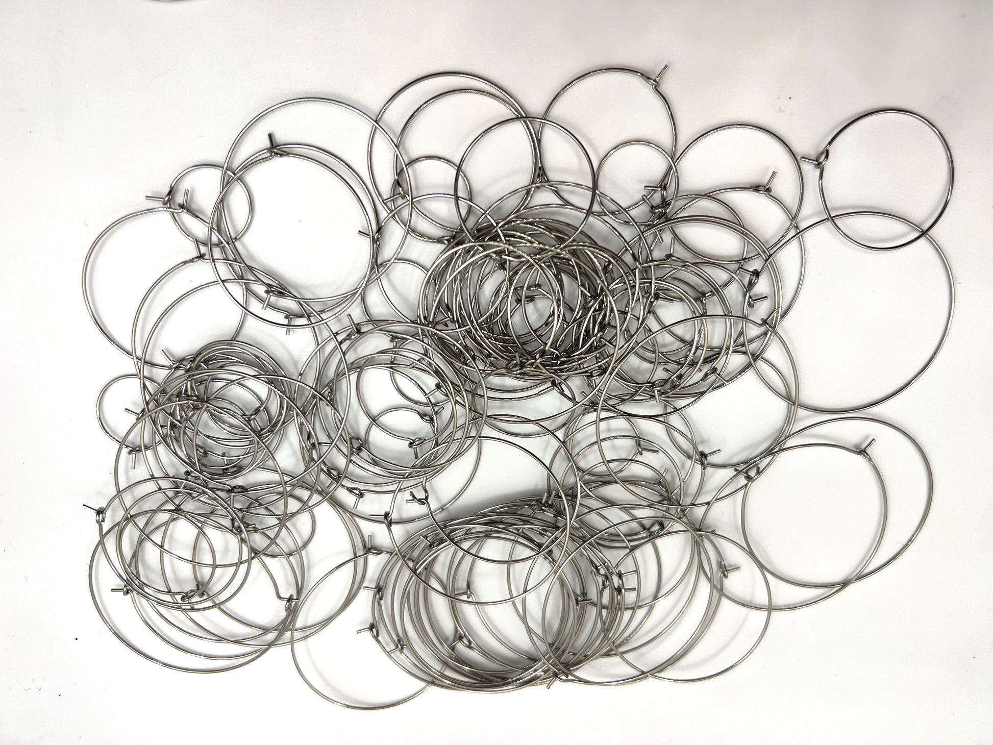 A pile of 120 stainless steel wine glass charm rings in various sizes.