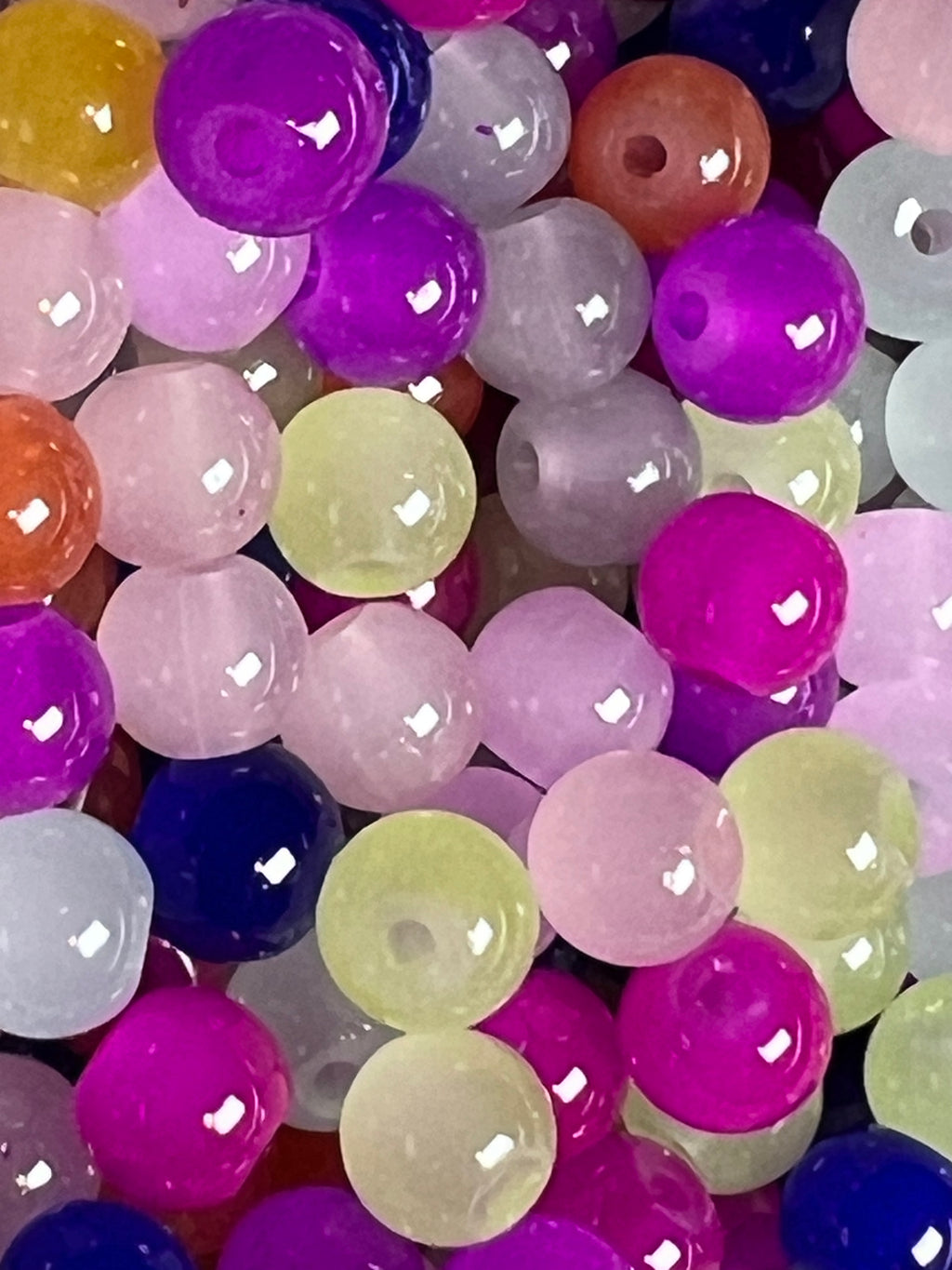 A close-up view of assorted 6mm glass imitation jade beads in a variety of vibrant colors.