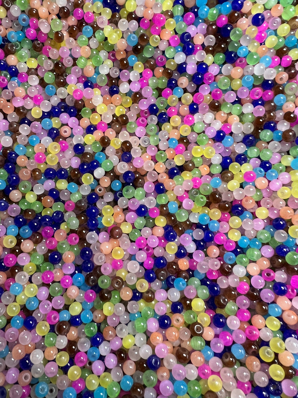 A pile of small, round, multicolored glass imitation jade beads in various vibrant hues.