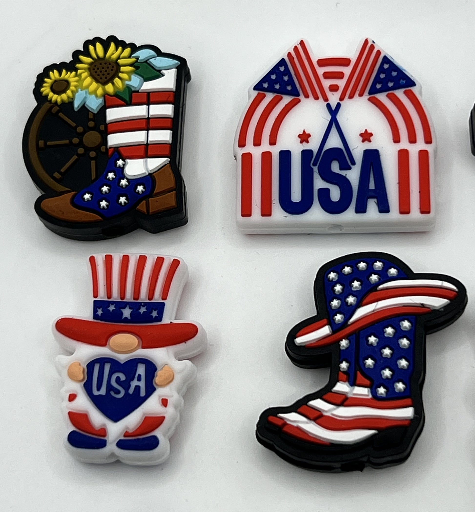 Four patriotic silicone focal beads featuring a sunflower boot, USA text, a gnome, and a cowboy boot.