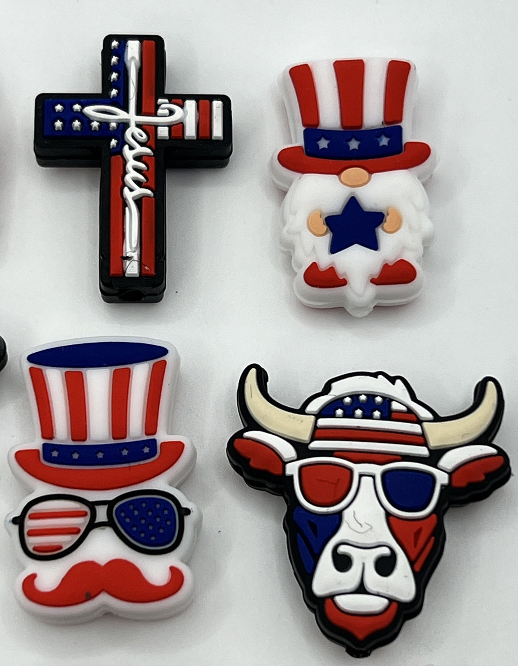 Four patriotic silicone focal beads featuring a cross, a gnome, a mustache man, and a bull.