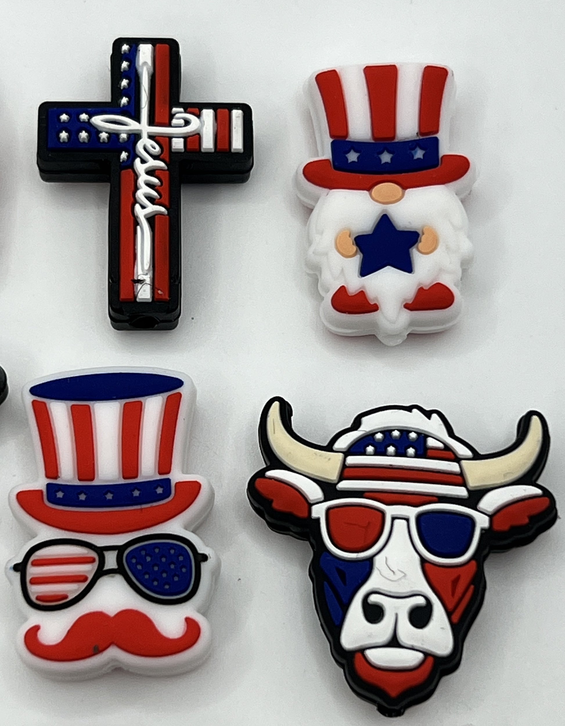 Four patriotic silicone focal beads featuring a cross, a gnome, a mustache man, and a bull.