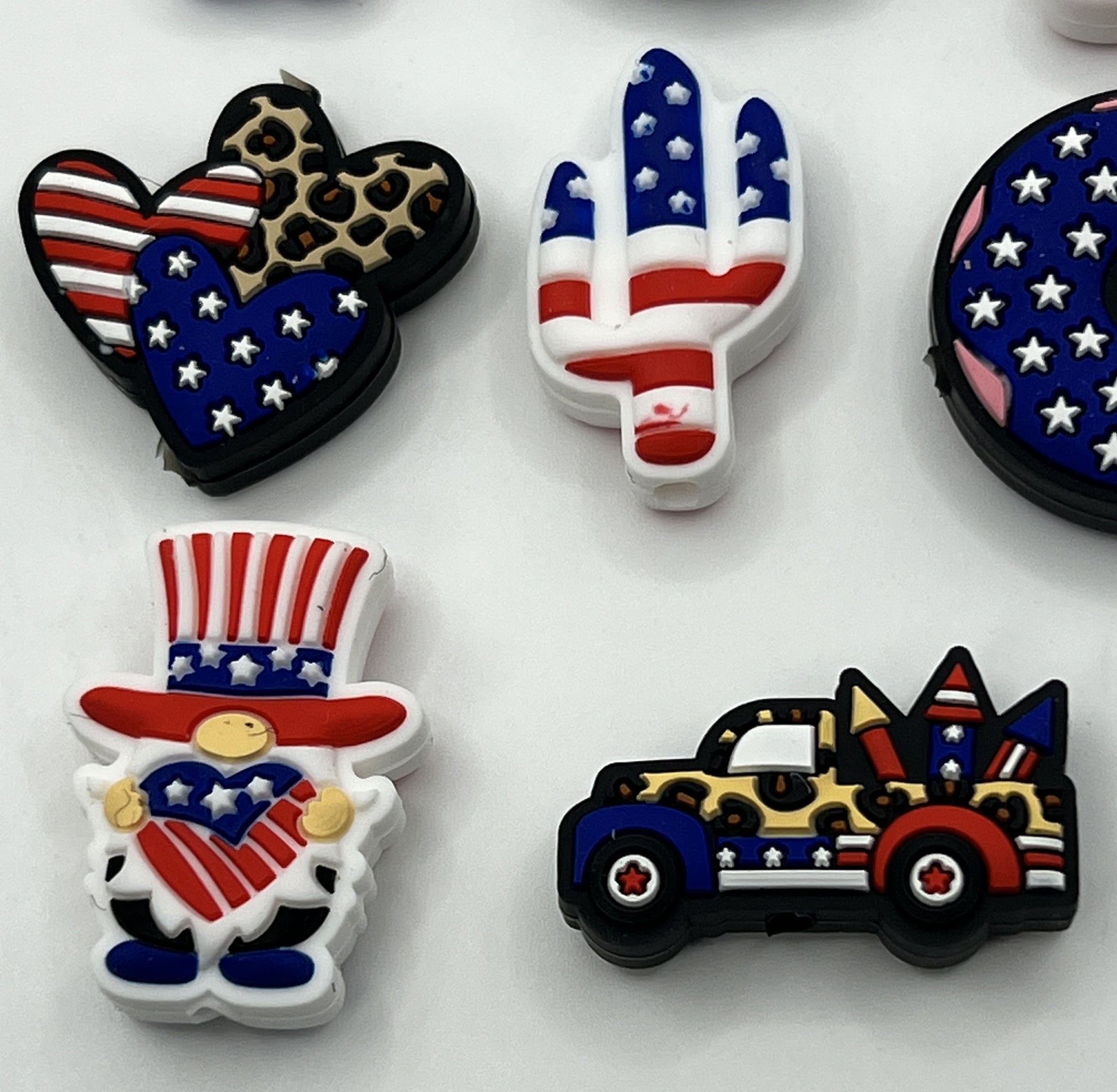 A set of patriotic silicone focal beads featuring designs like a gnome, truck, and cactus.