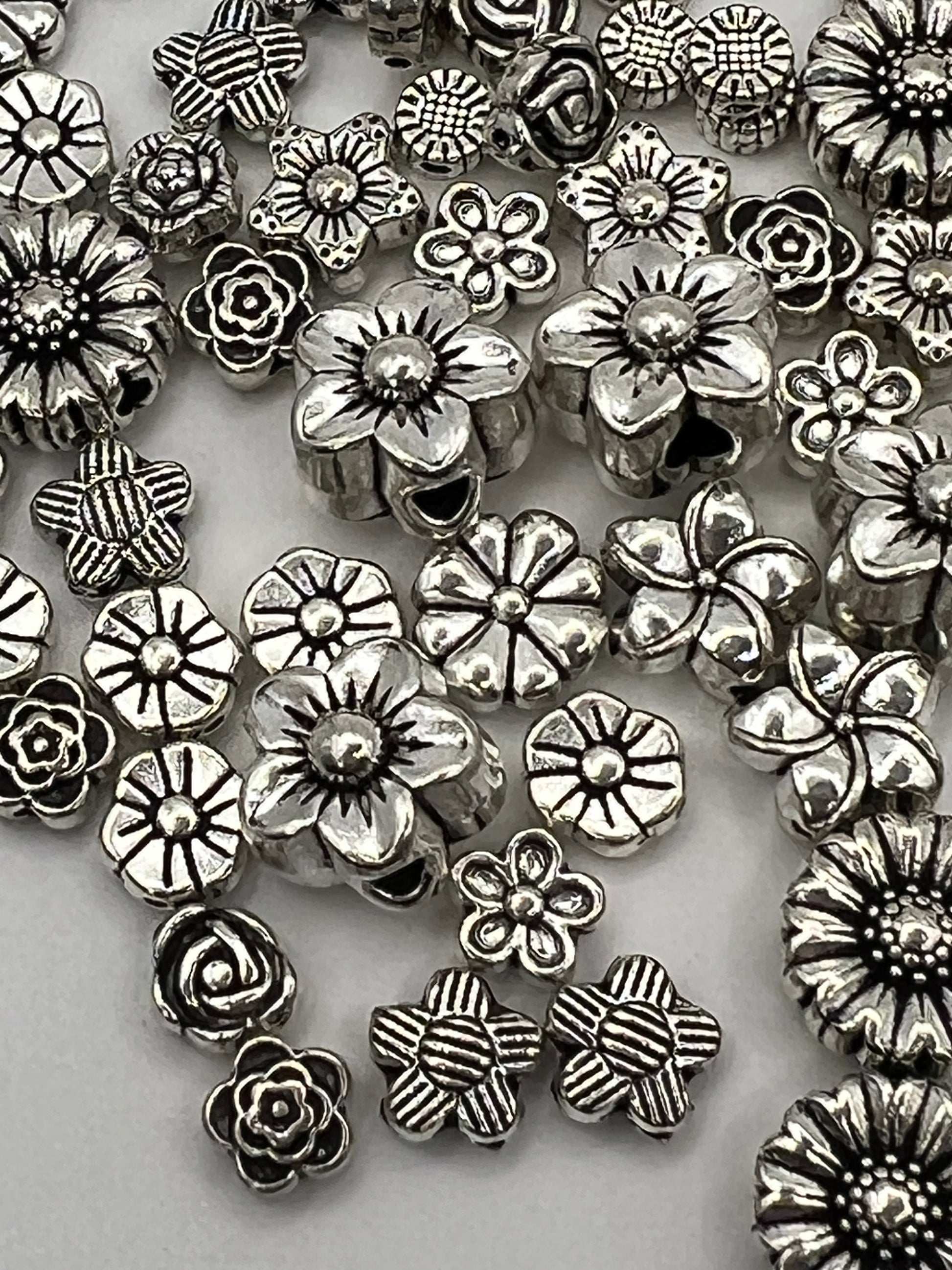 120pc Tibetan style flower beads in antique silver with 12 distinct designs.