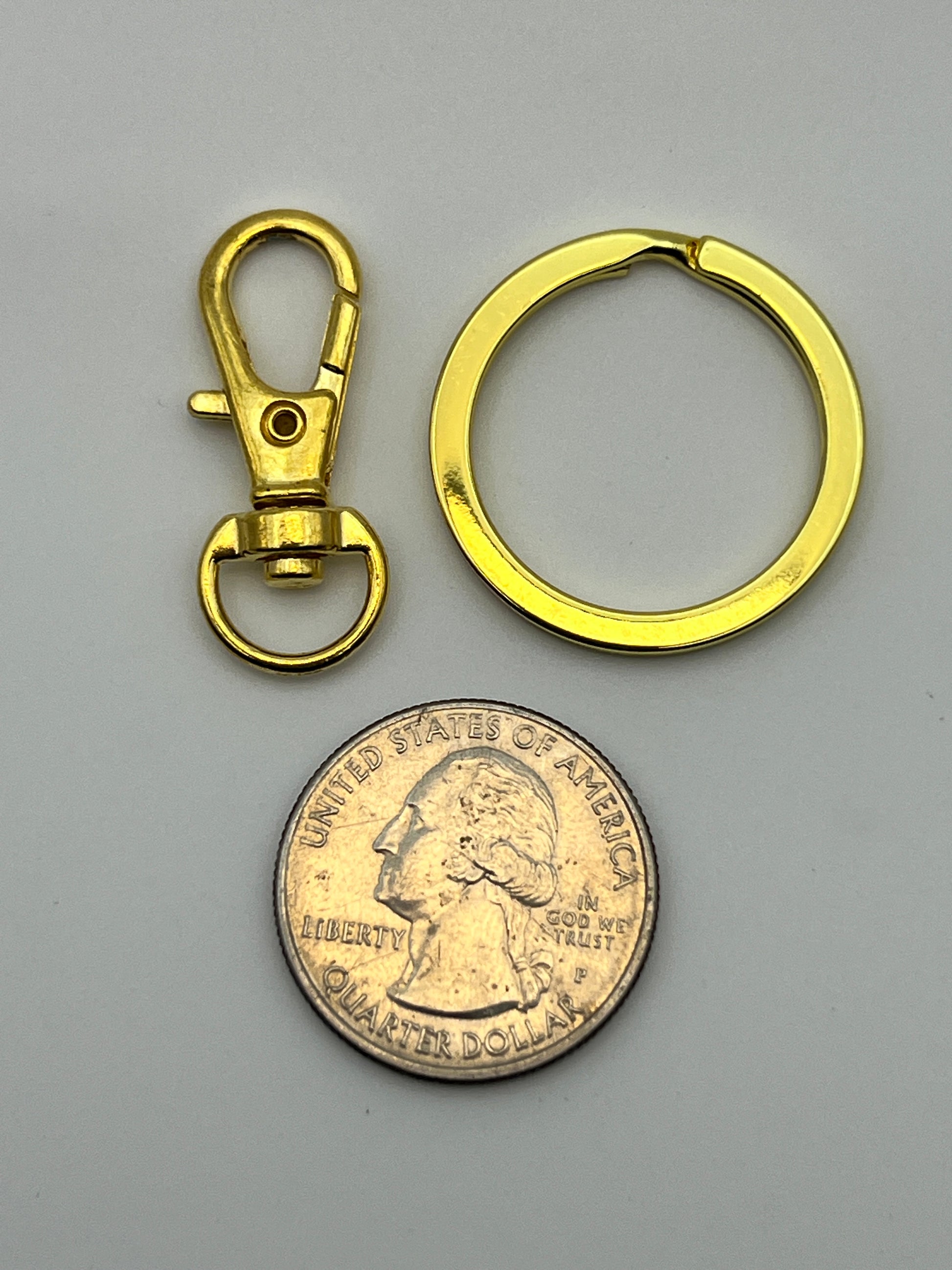 Golden split key ring and swivel lobster clasp shown next to a US quarter for scale.