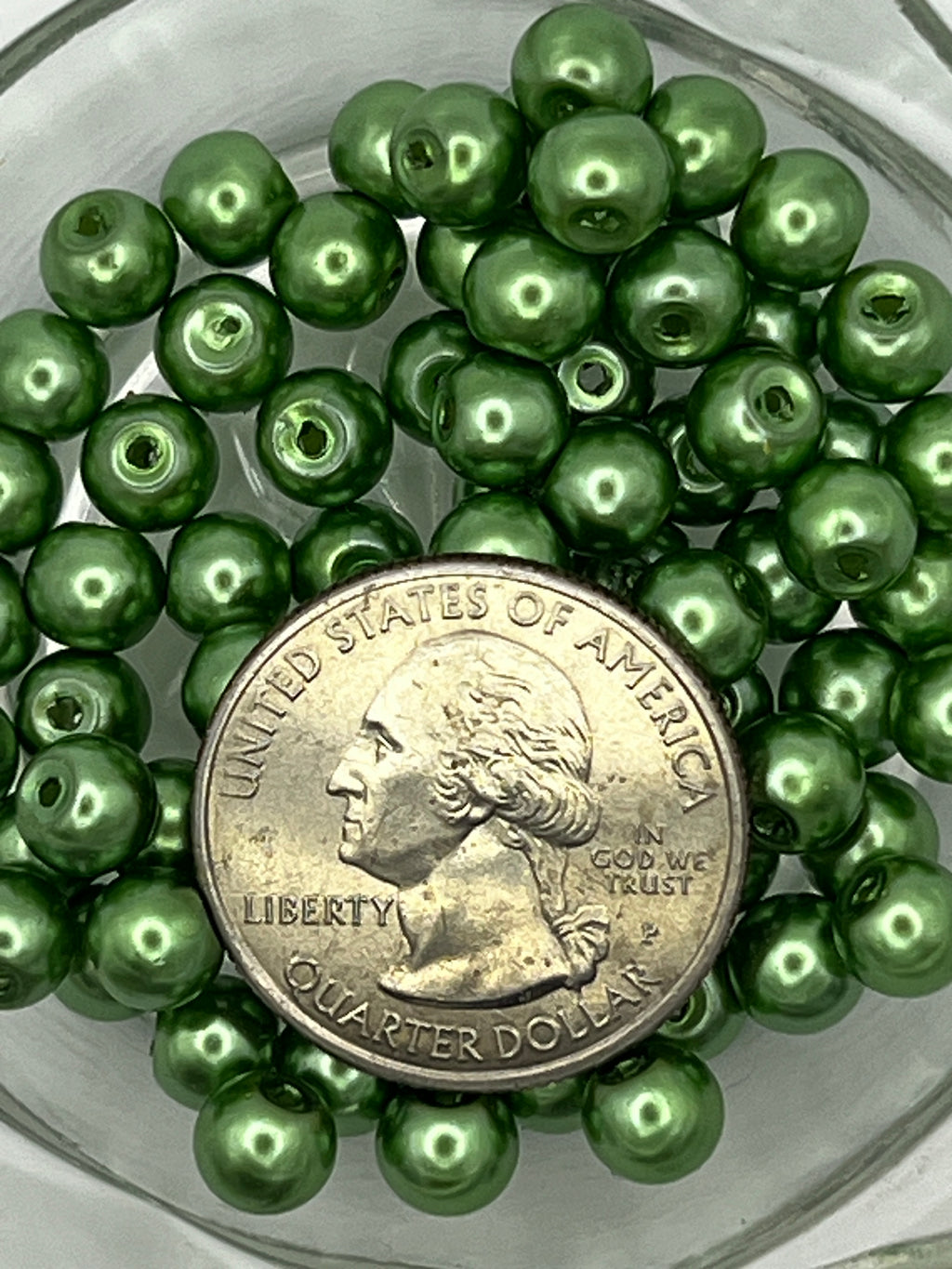 6mm green glass pearl beads shown with a US quarter for size reference.