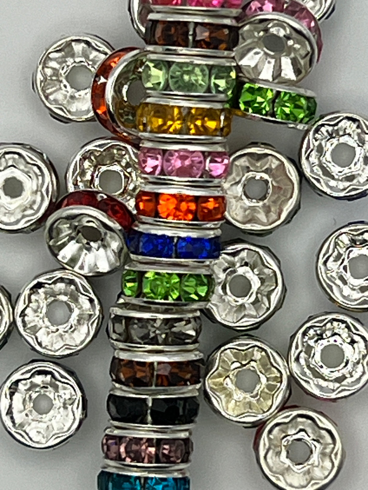 Assorted 8mm silver-plated spacer beads with colorful glass rhinestones in a stacked arrangement.