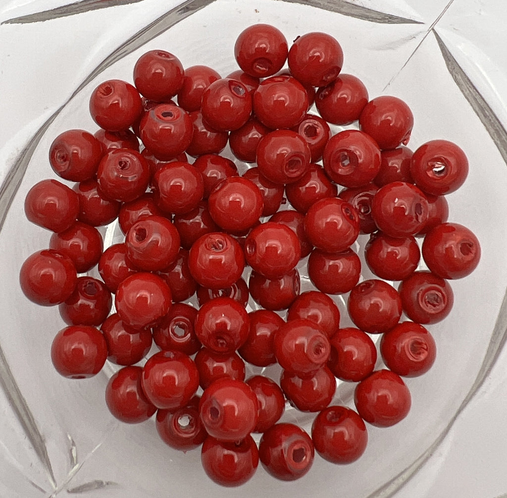 A pile of 6mm round red glass pearl beads with a 1mm hole, suitable for jewelry making.