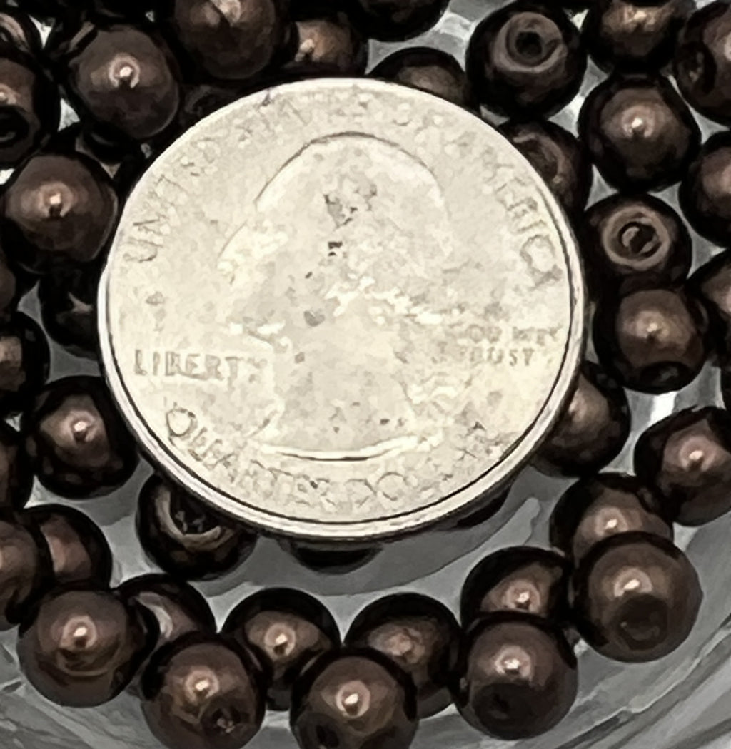 6mm saddle brown glass pearl beads with a quarter for scale.