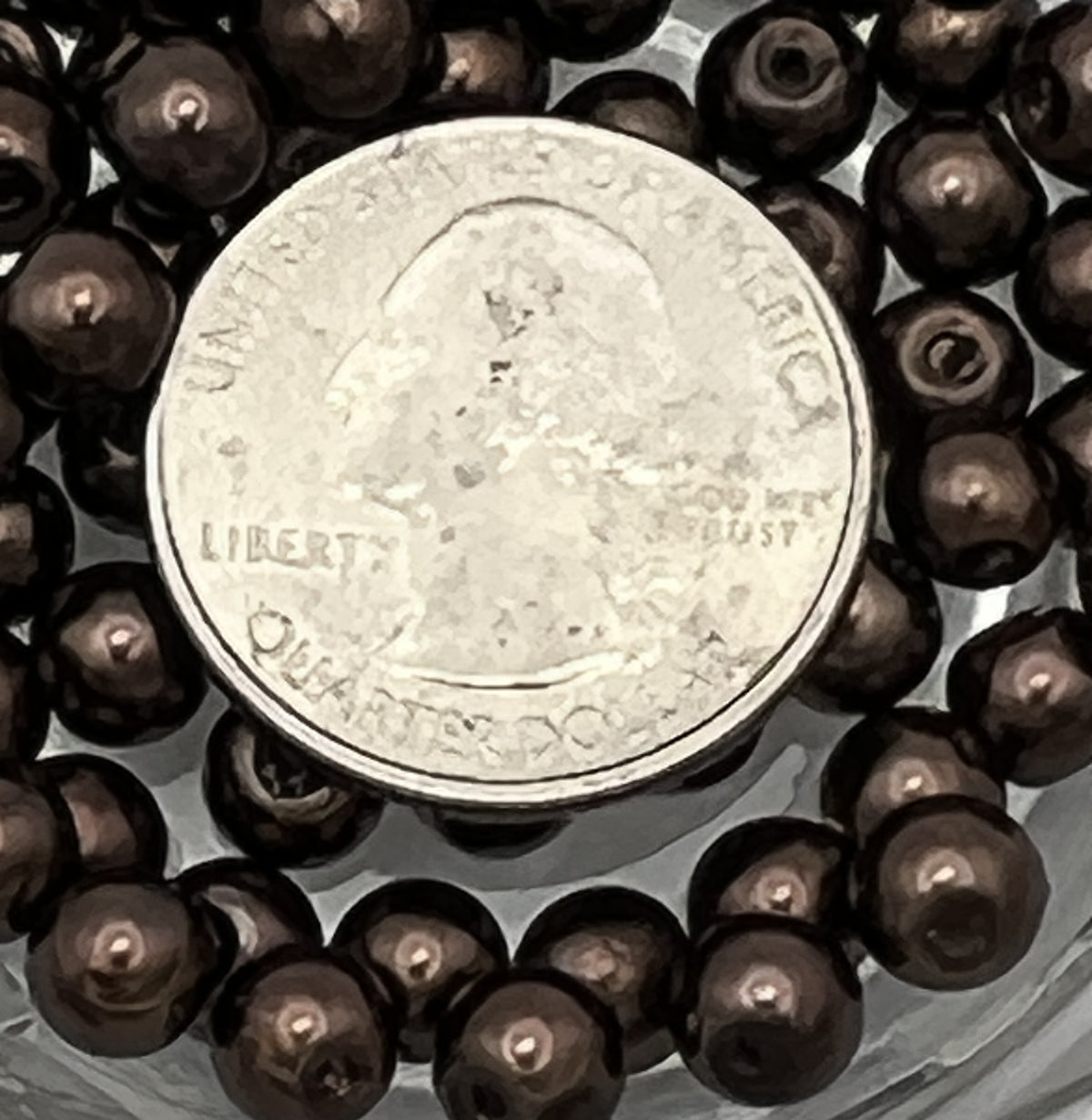 6mm saddle brown glass pearl beads with a quarter for scale.