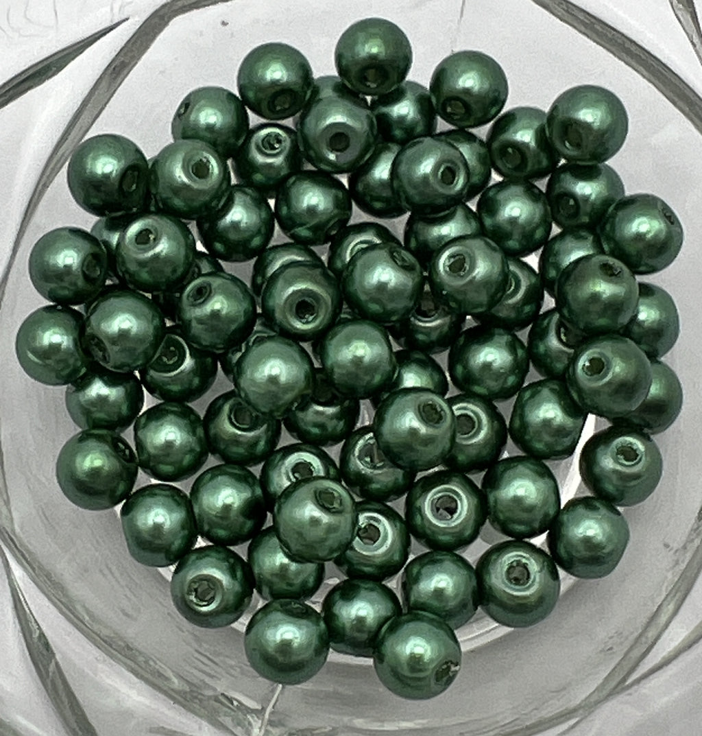 A pile of 6mm dark green glass pearl beads with a 1mm hole.