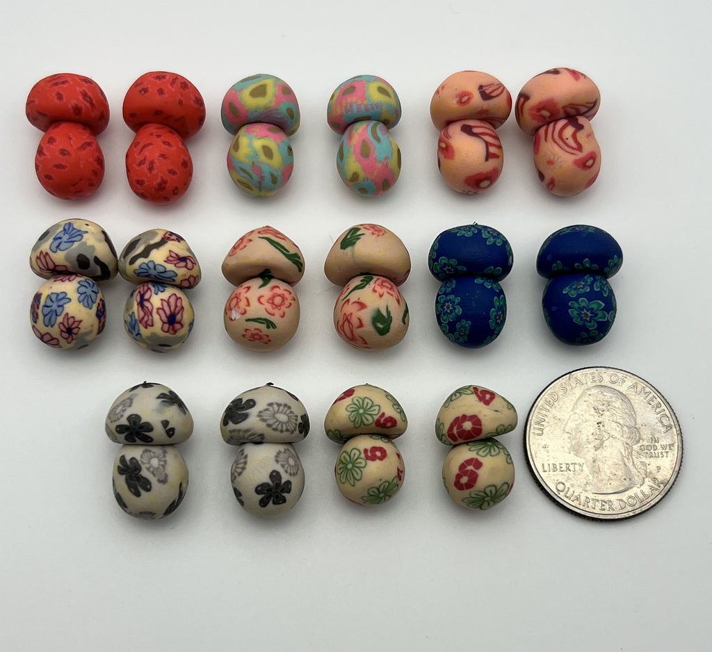 Set of 16 assorted polymer clay mushroom beads in various patterns next to a US quarter for scale.