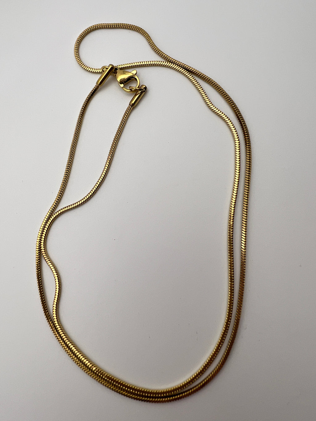 20-inch golden 304 stainless steel snake chain necklace with a lobster clasp on a white background.