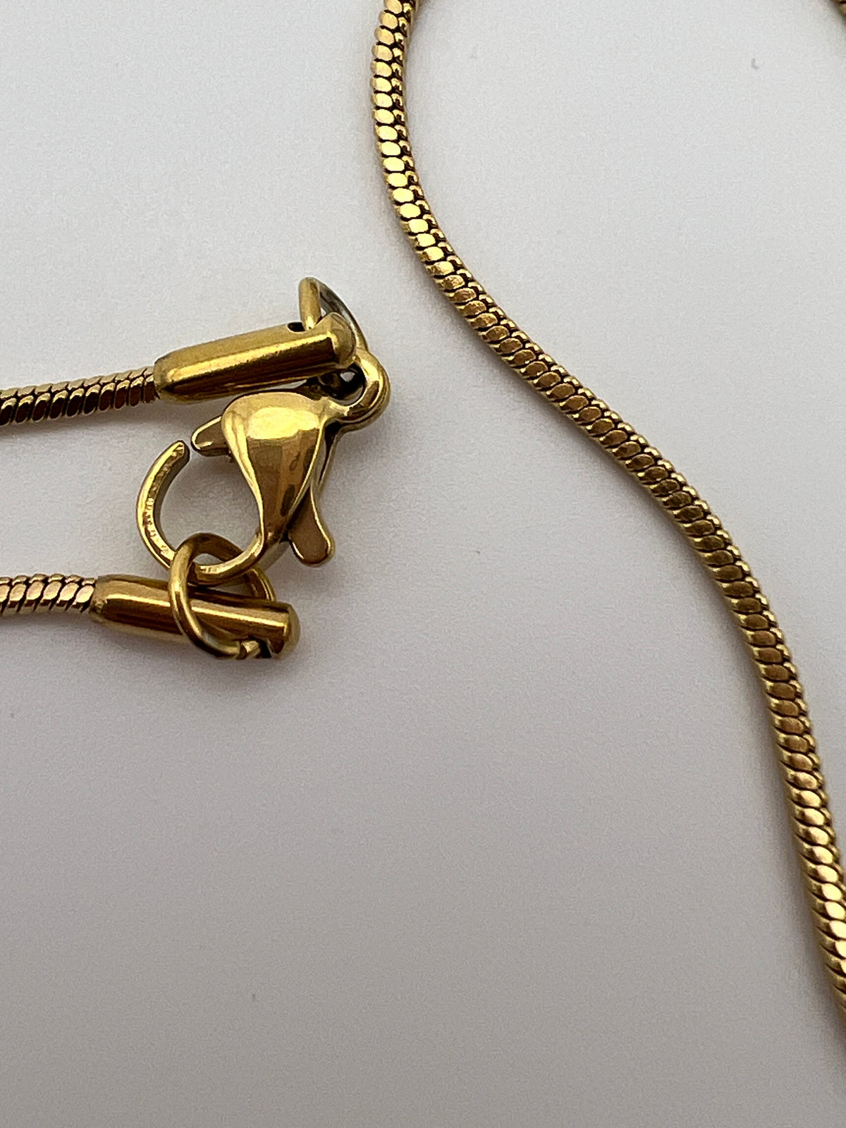Close-up of a 20-inch golden 304 stainless steel snake necklace with a lobster claw clasp.