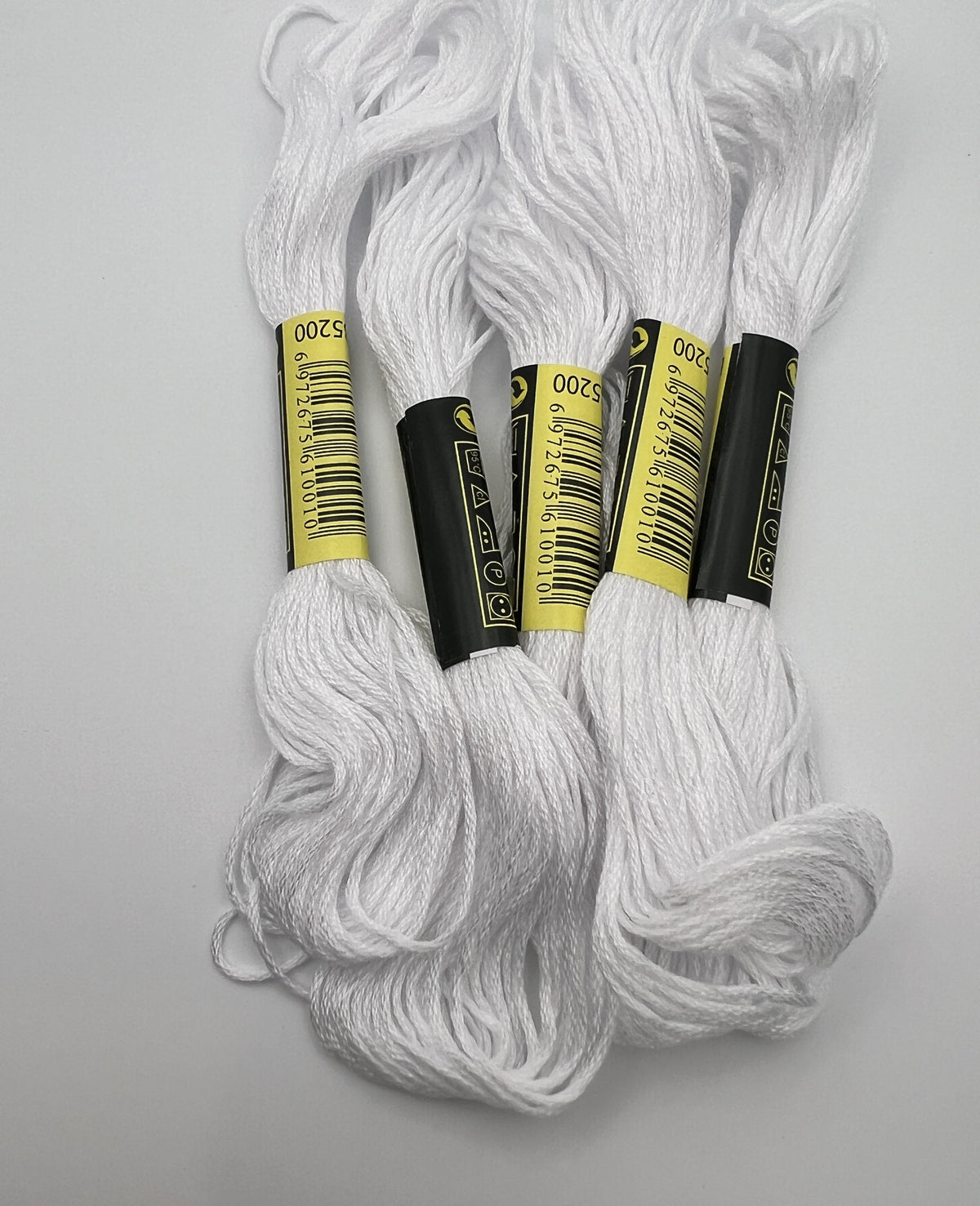 Five skeins of 1.4mm white embroidery thread with yellow and black labels showing code 5200.