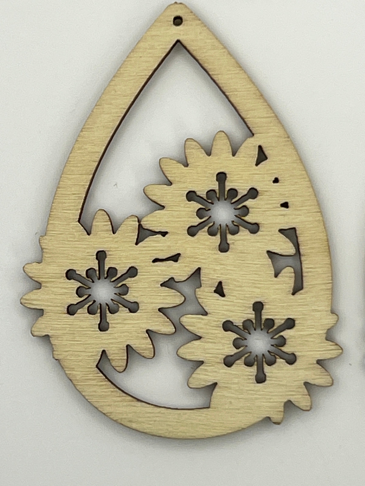 Teardrop-shaped natural wood pendant with three intricate cut-out flower designs and a top hole.