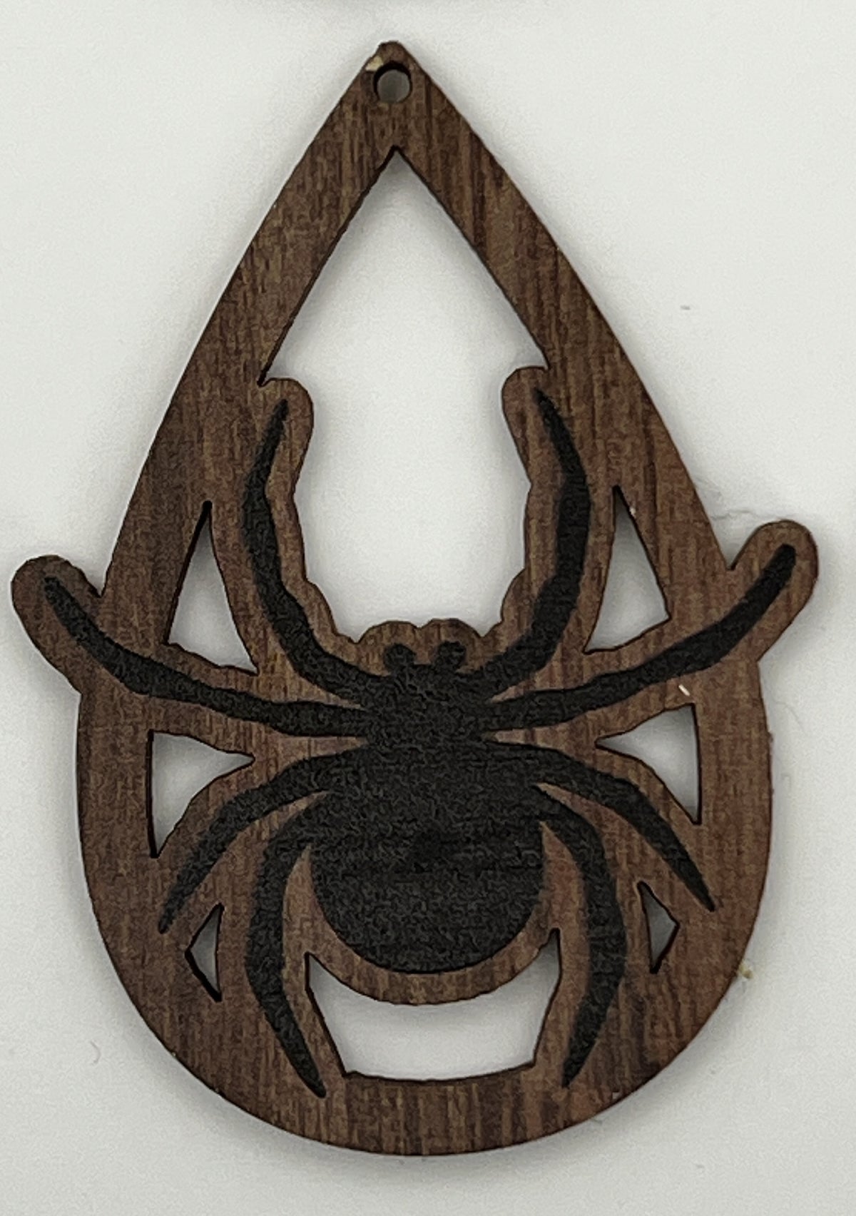 Teardrop-shaped wooden pendant with a laser-cut and printed black spider design.