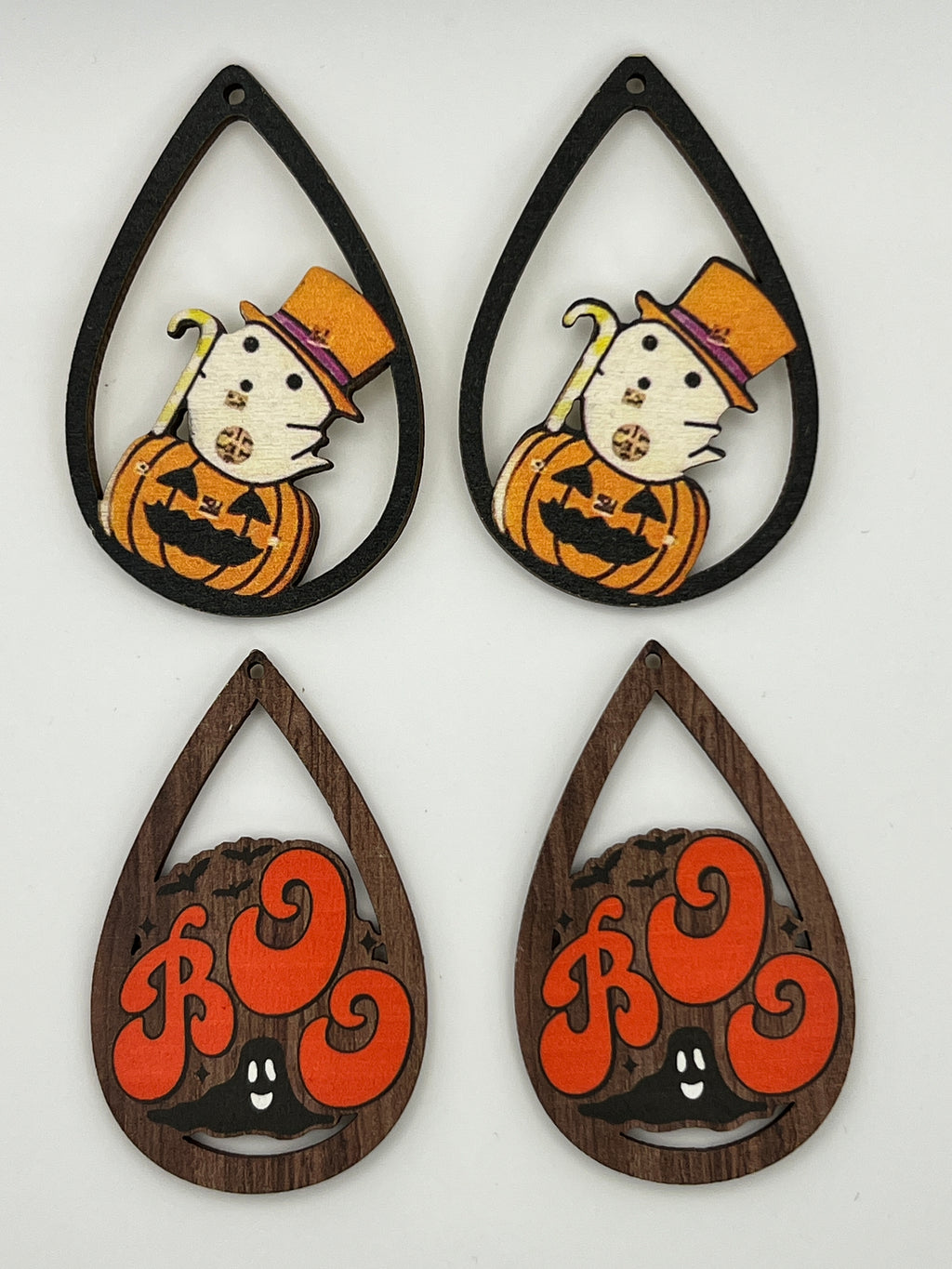 Four teardrop-shaped wood pendants: two with a ghost in a top hat and two with orange 'Boo' text.