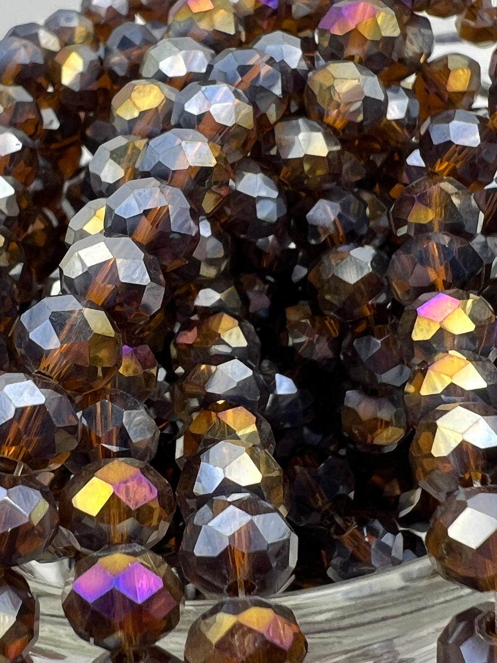 Faceted 8x6mm saddle brown glass rondelle beads with iridescent AB electroplated finish.