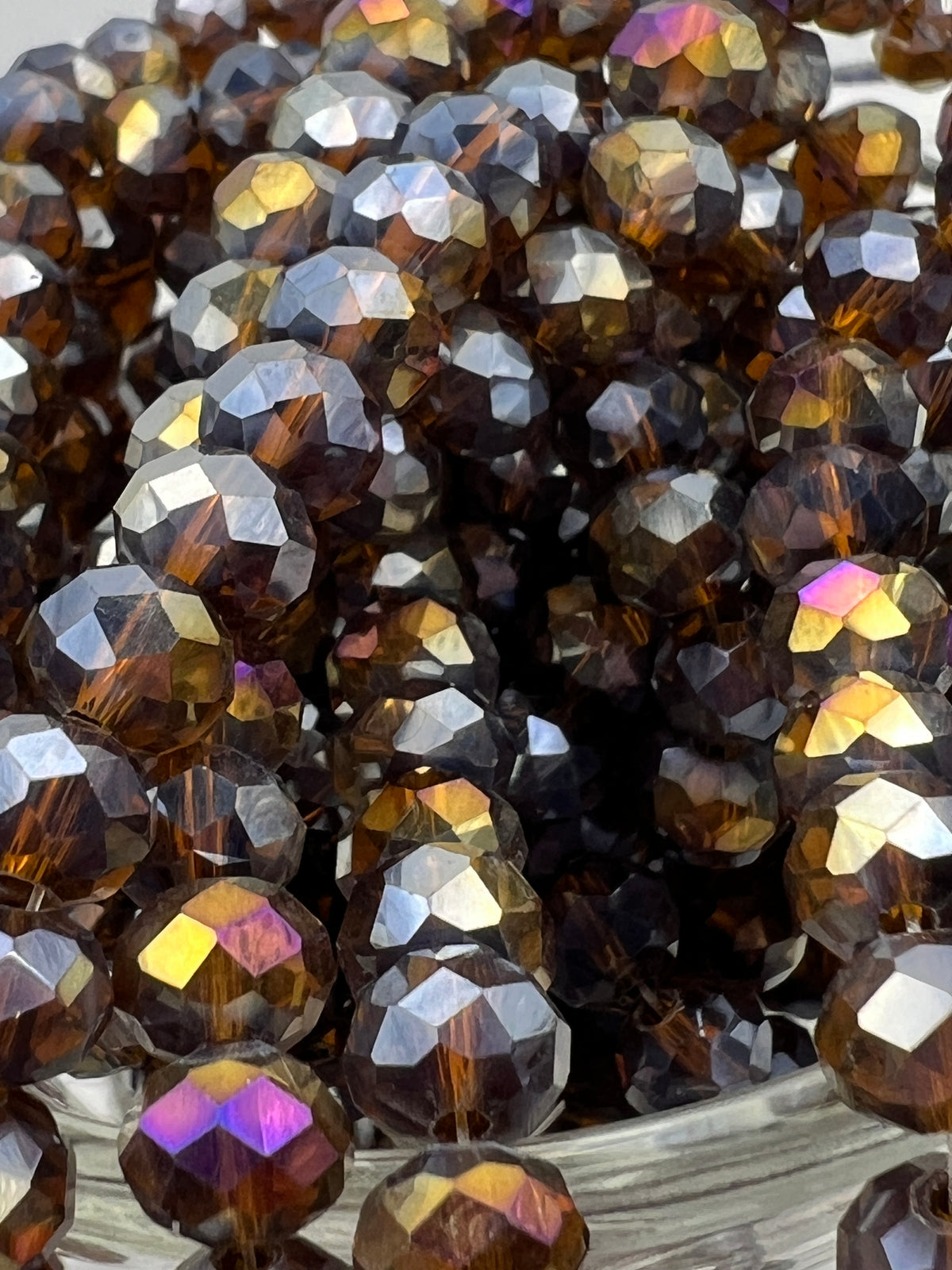 Faceted 8x6mm saddle brown glass rondelle beads with iridescent AB electroplated finish.