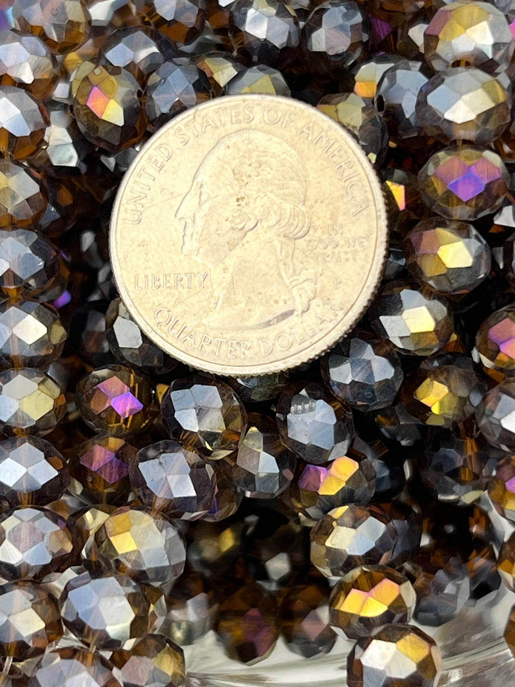 8x6mm saddle brown AB color plated faceted glass rondelle beads shown with a US quarter for scale.