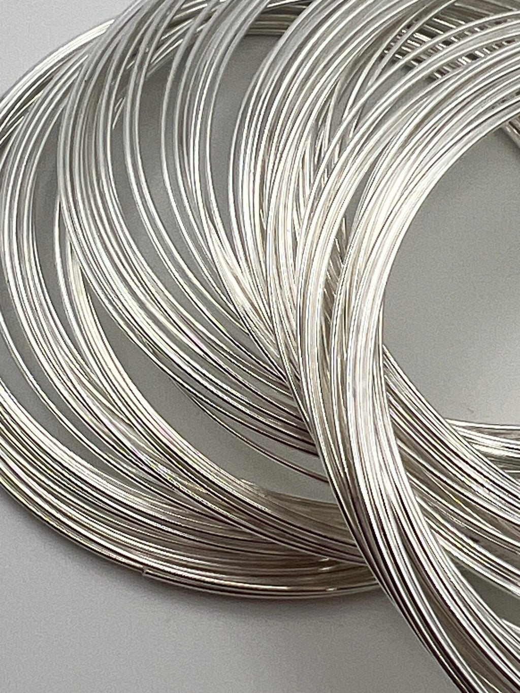 Close-up of 100 loops of silver-colored carbon steel memory wire for bracelet making.